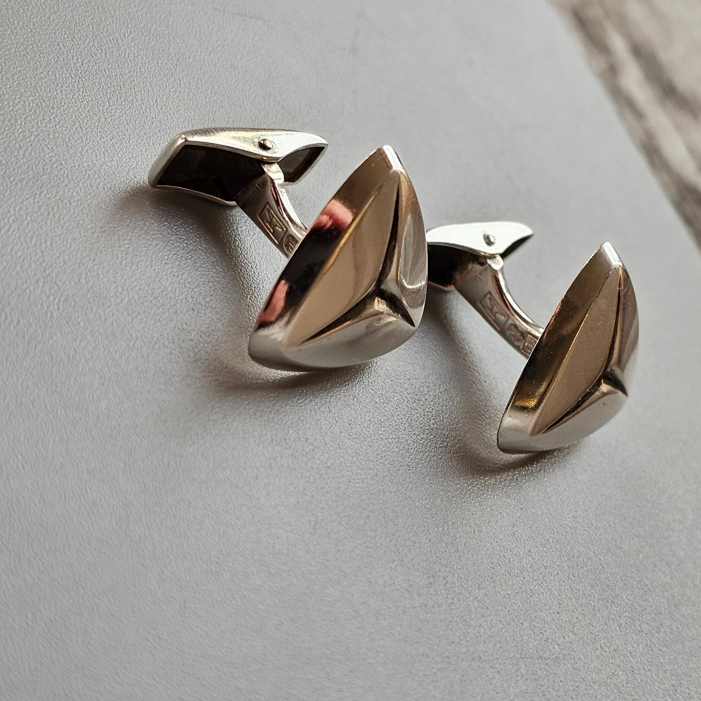 Pair of silver cufflinks with a sleek, modern design.
