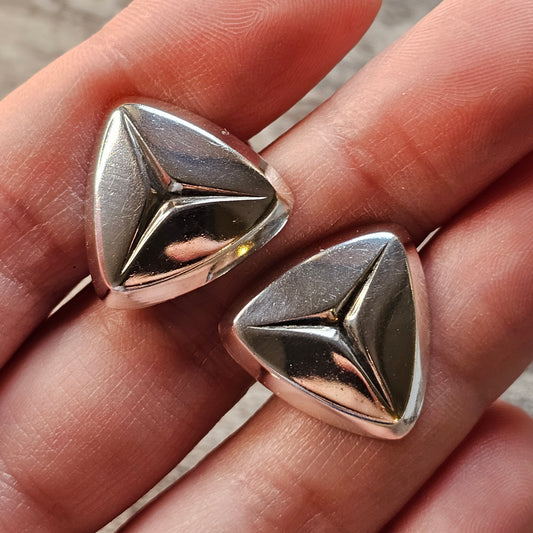 Pair of triangular silver-colored metal cufflinks with a three-dimensional geometric design.