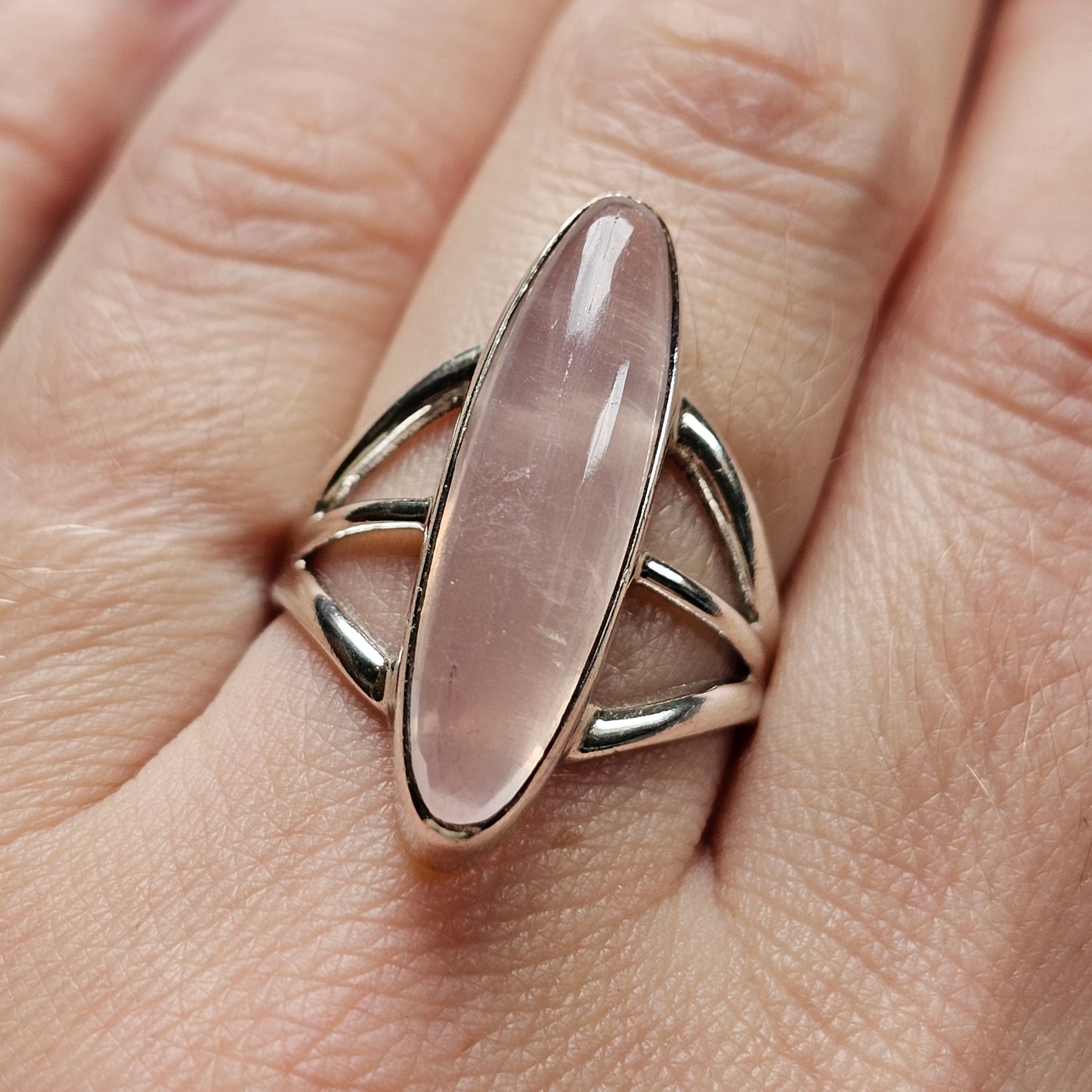 Silver ring with an elongated oval rose quartz gemstone.