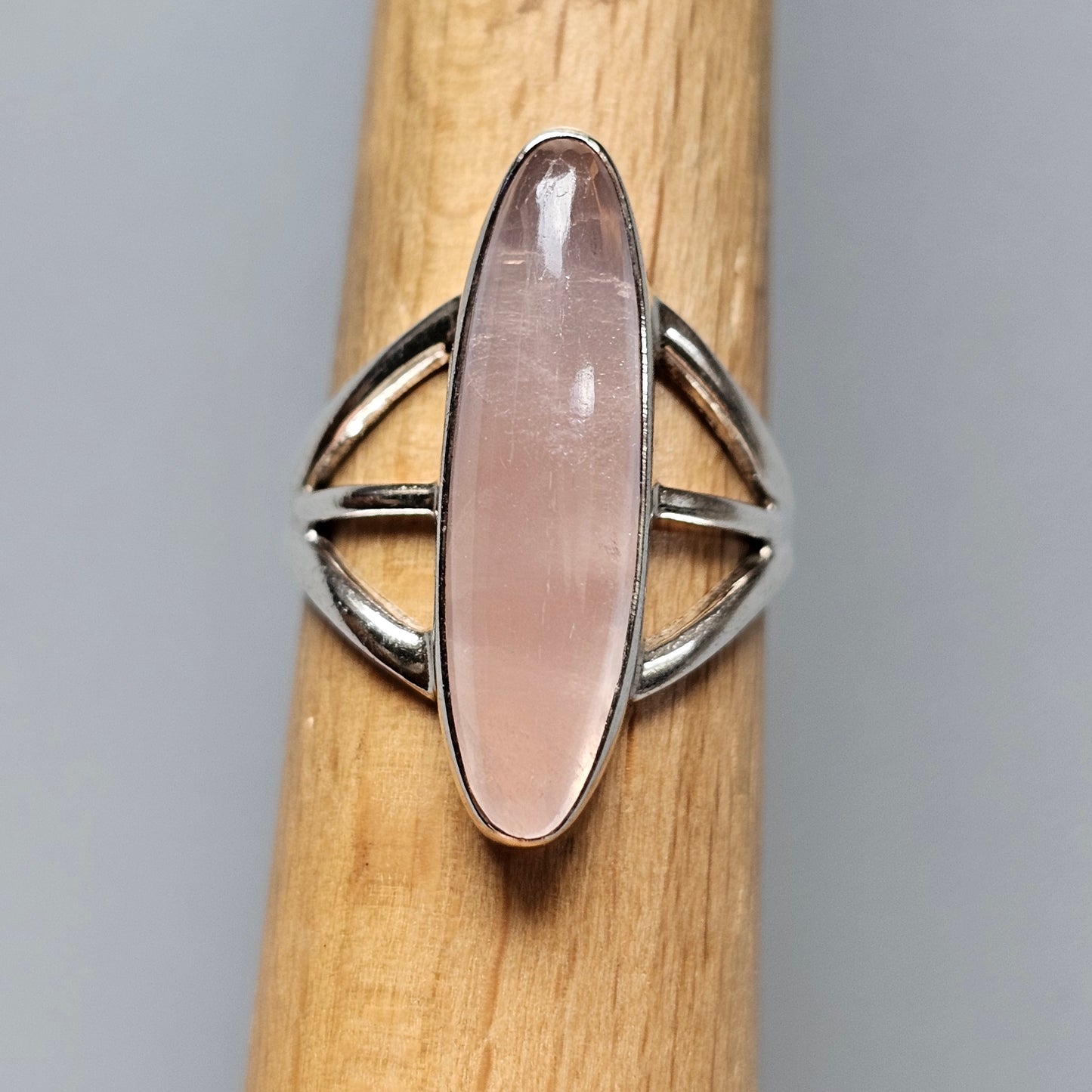Silver ring with an elongated oval rose quartz gemstone.