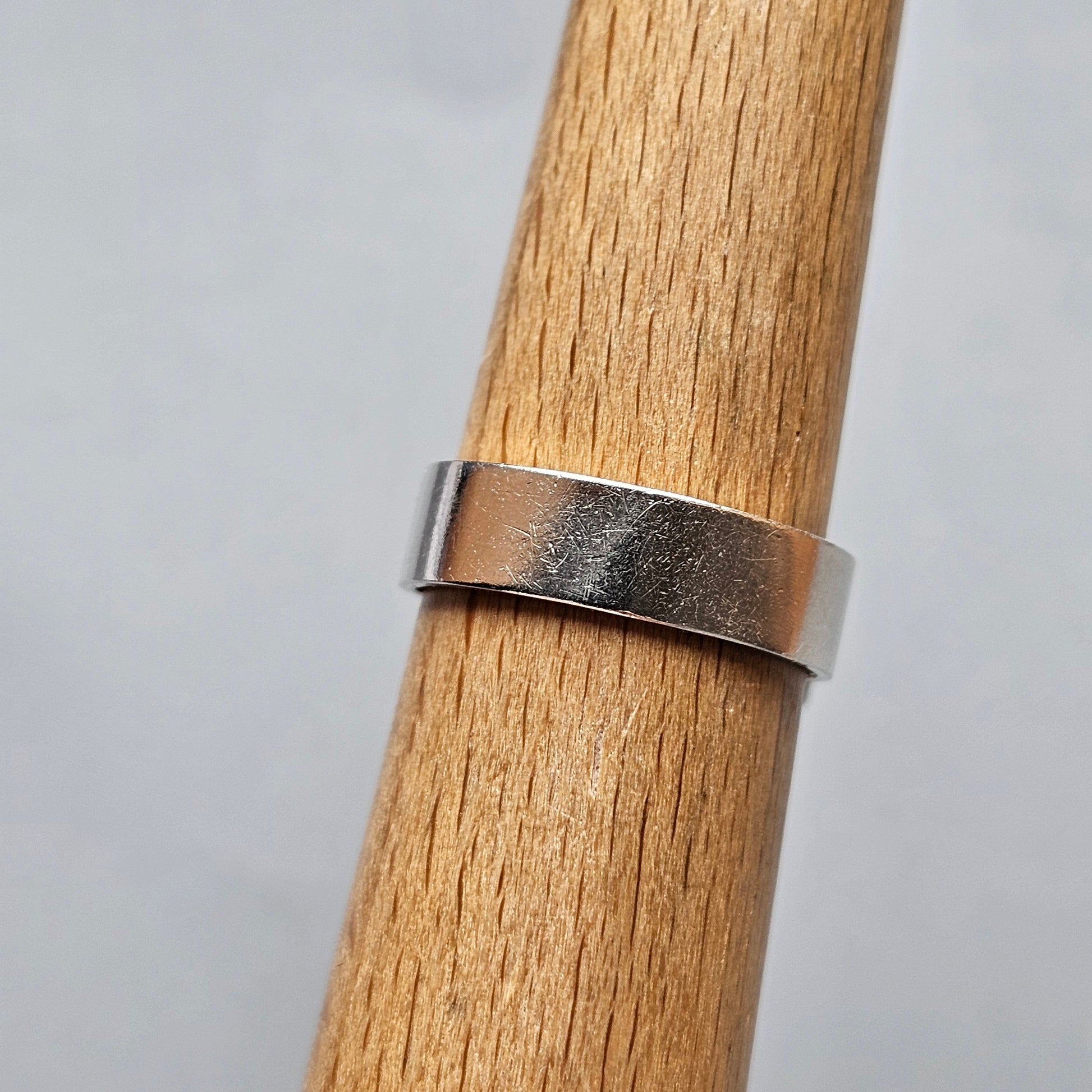 Silver metal ring on a wooden surface.