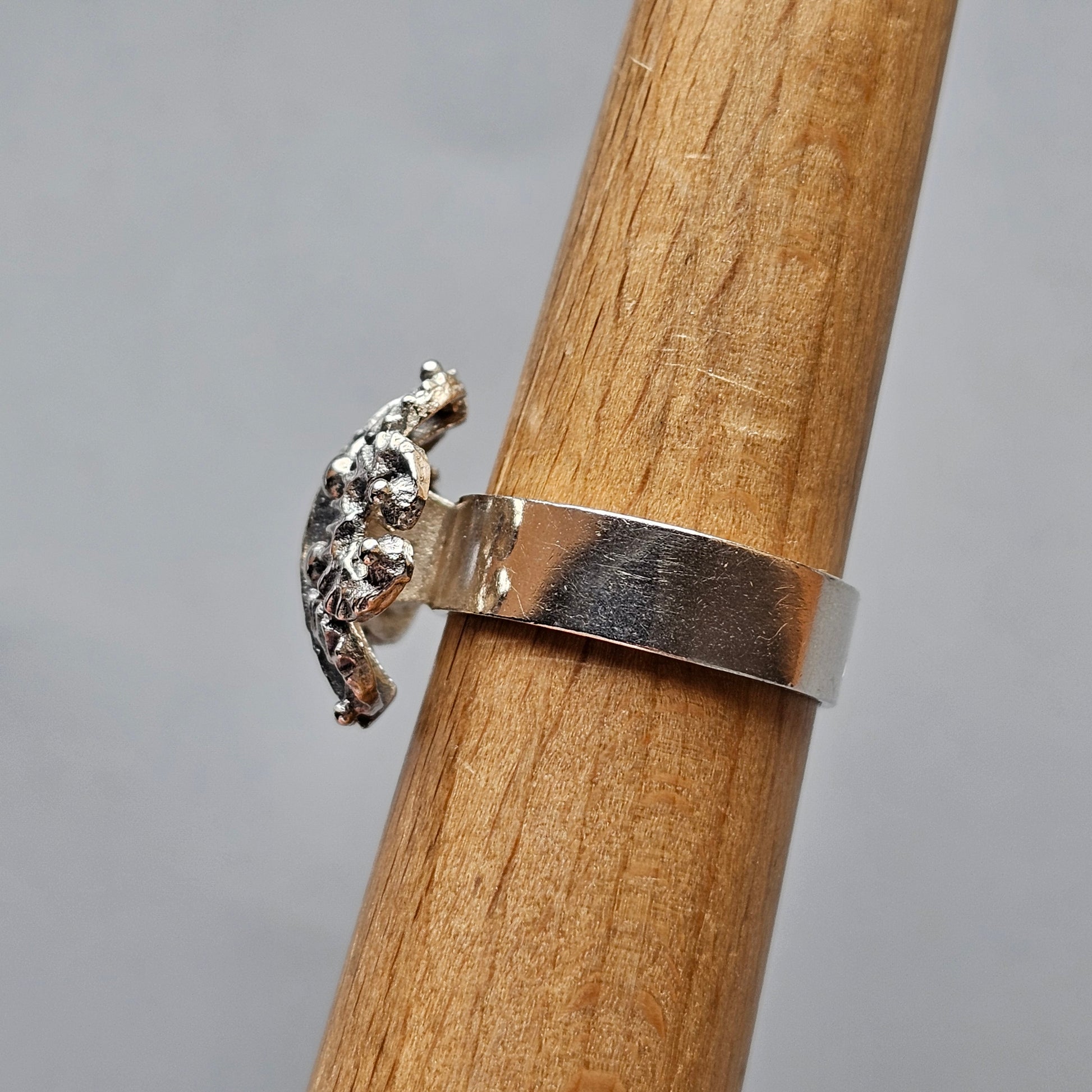 Silver ring with a decorative leopard or cheetah figure attached to the band.