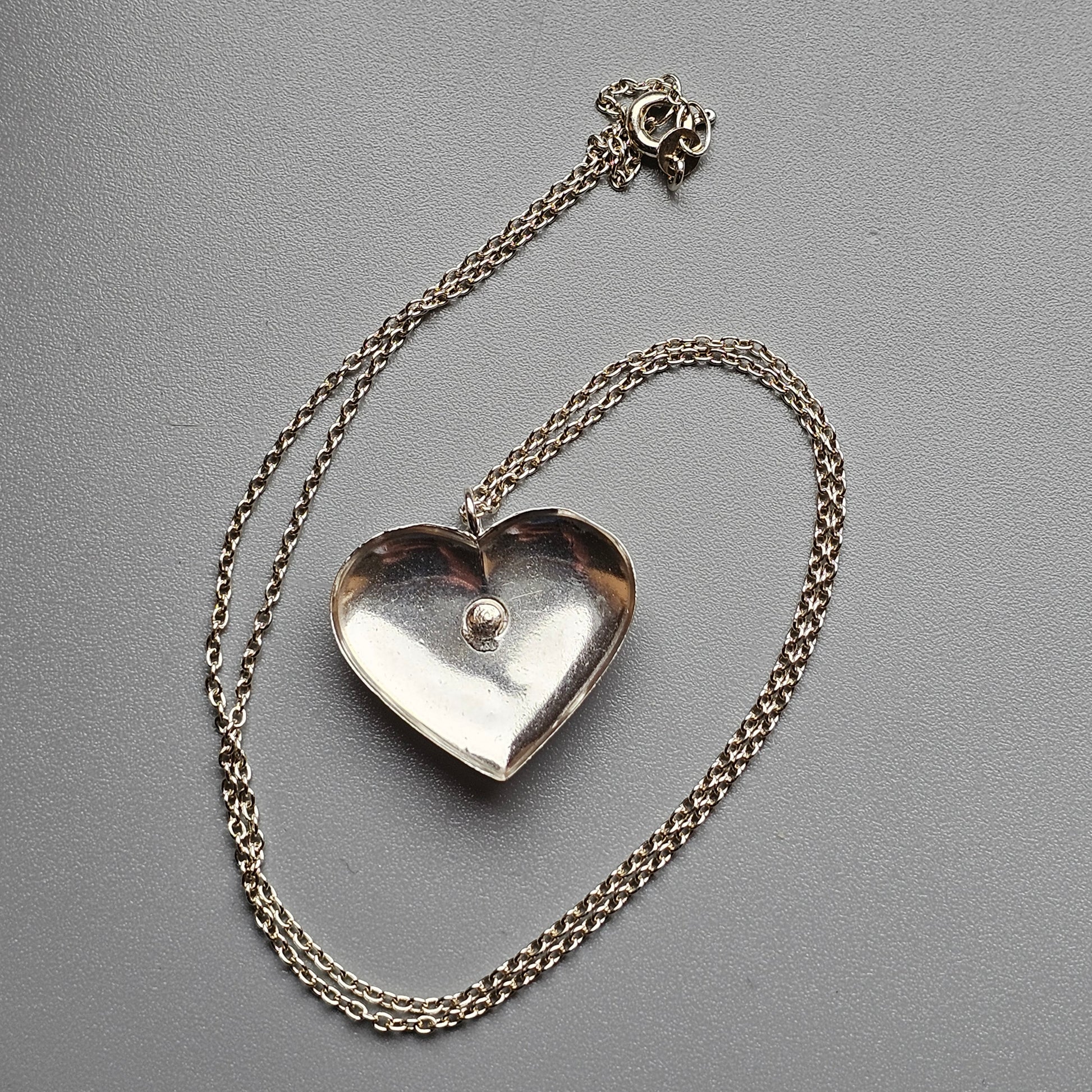 Heart-shaped silver pendant on a delicate chain necklace.