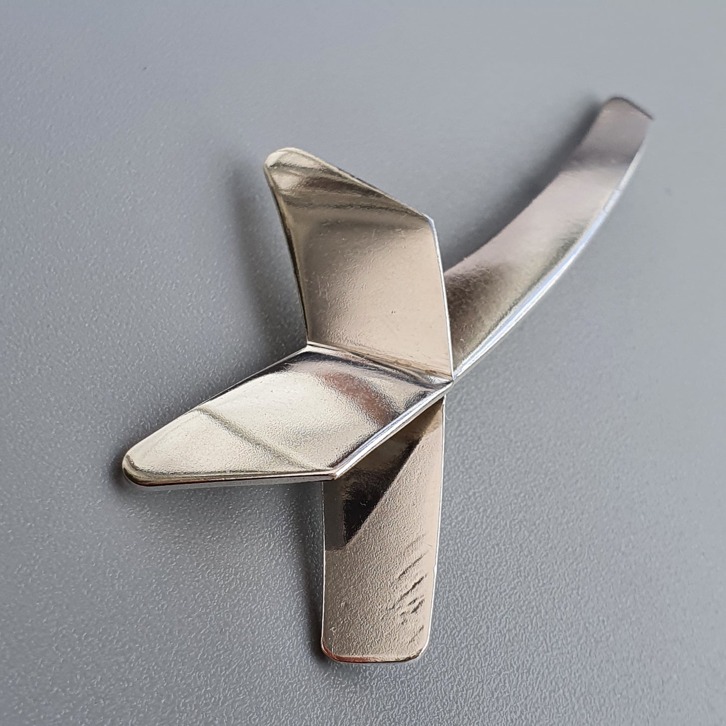 Metallic paper airplane or origami-style aircraft sculpture.