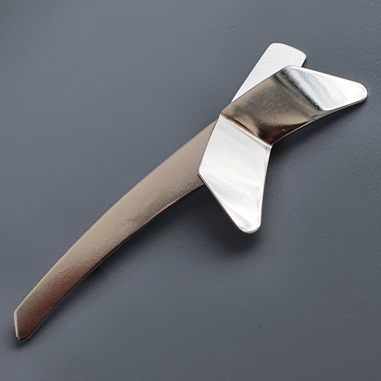 Sleek, metallic boomerang-shaped object with wing-like protrusions.