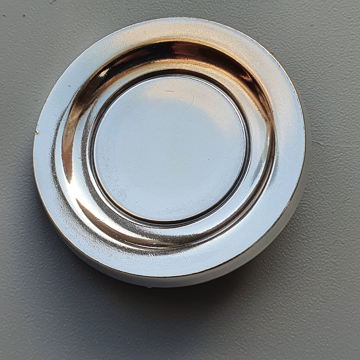 Circular recessed light fixture with a metallic rim.