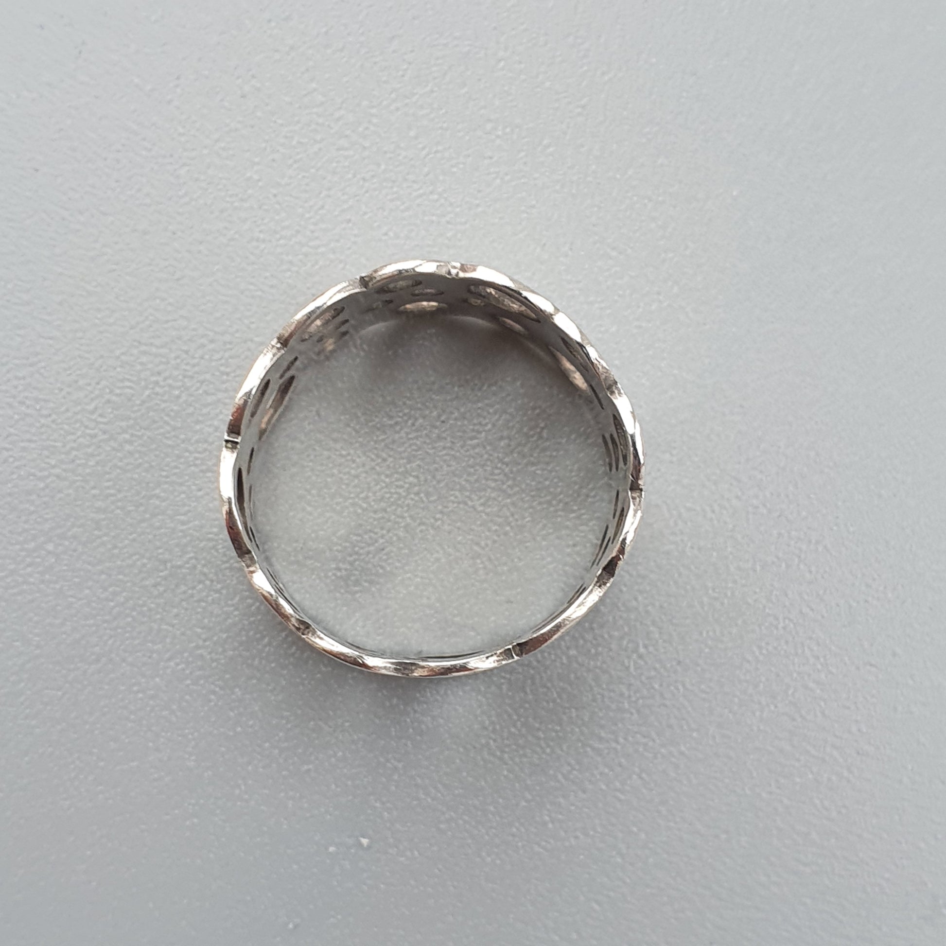 Silver ring with a twisted or braided design.