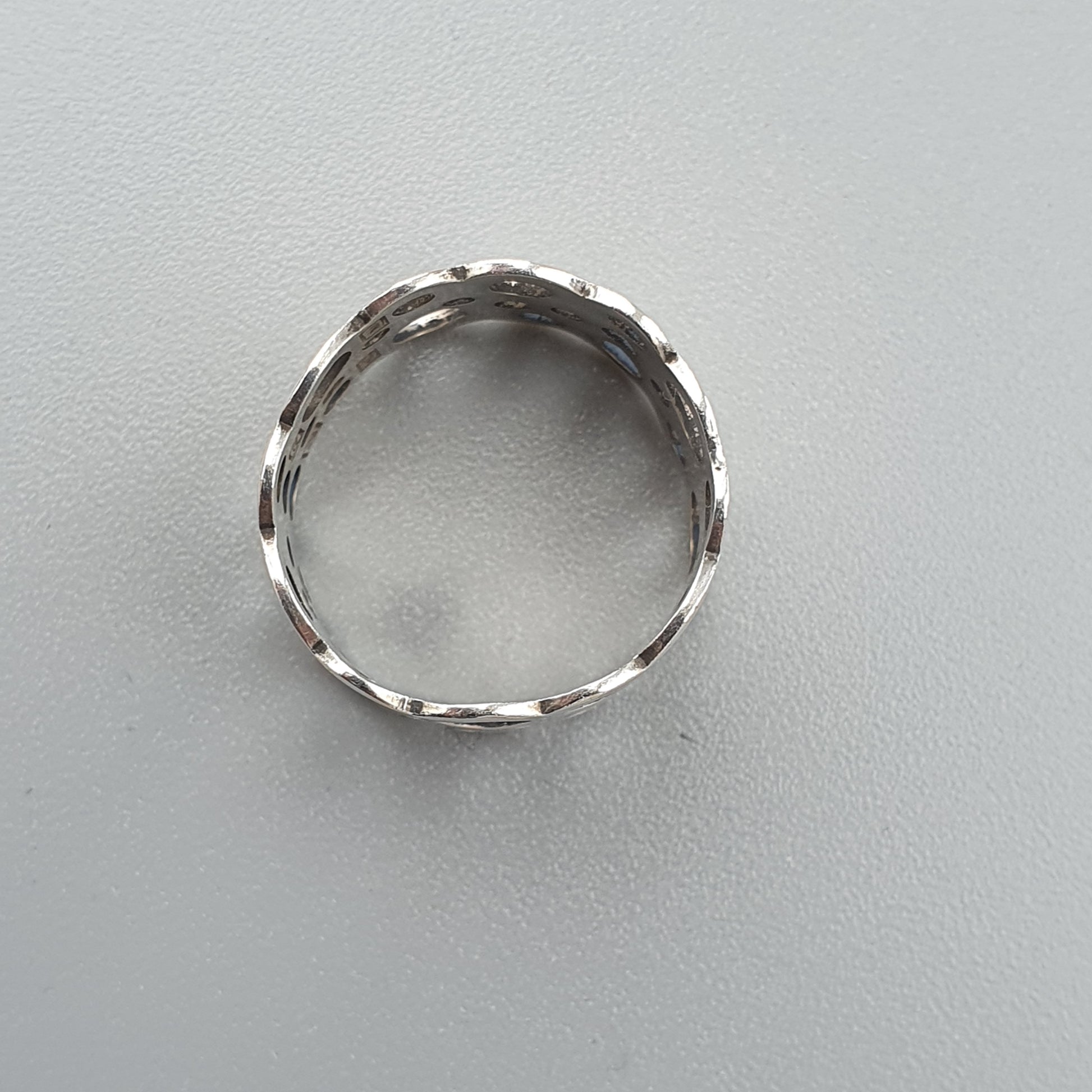 Silver ring with a textured or patterned band.