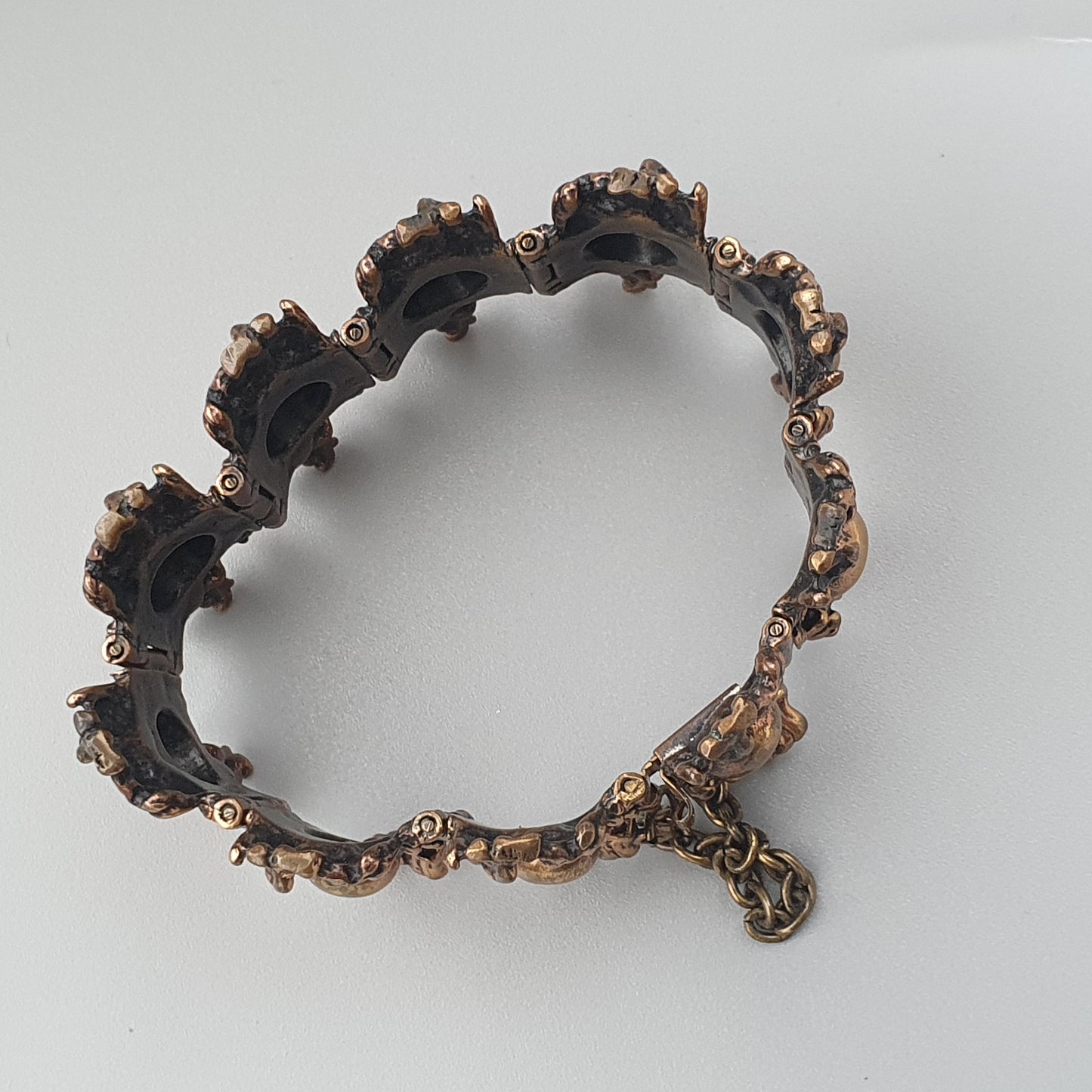 Ornate bronze bracelet with an irregular, scalloped edge and intricate decorative details.