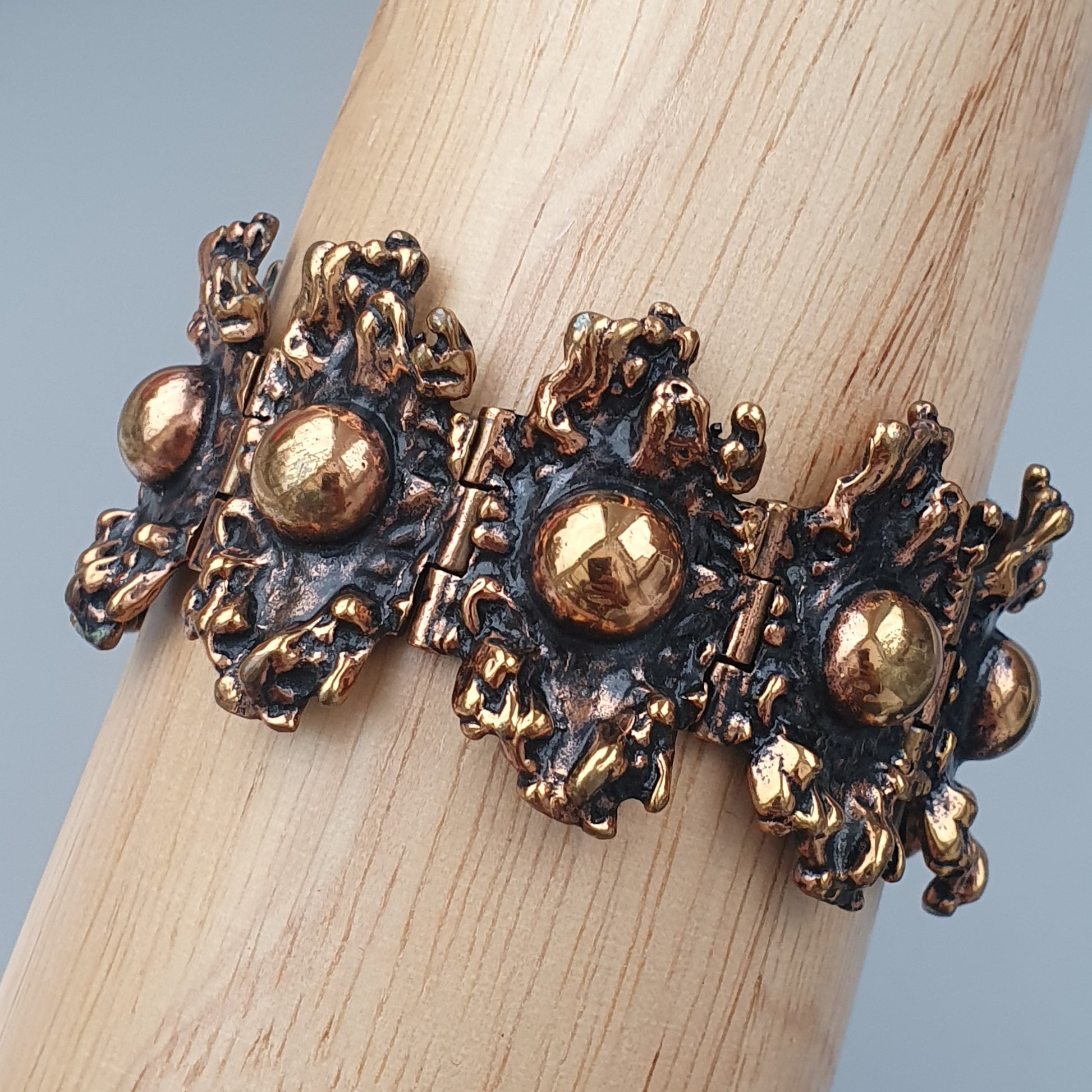 Ornate gold-toned bracelet with intricate metalwork and spherical accents.