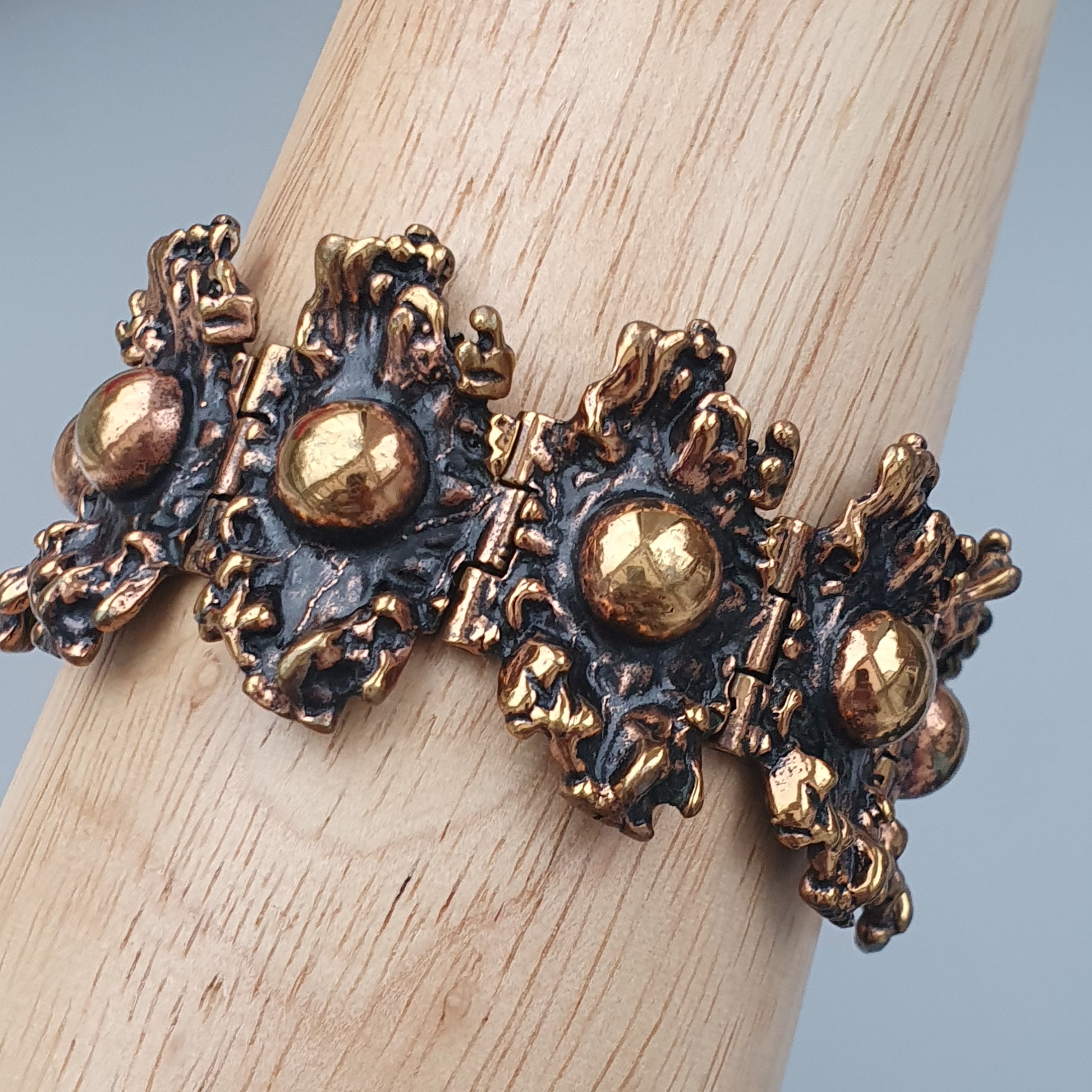 Ornate vintage-style bracelet with golden spheres and intricate metalwork detailing.