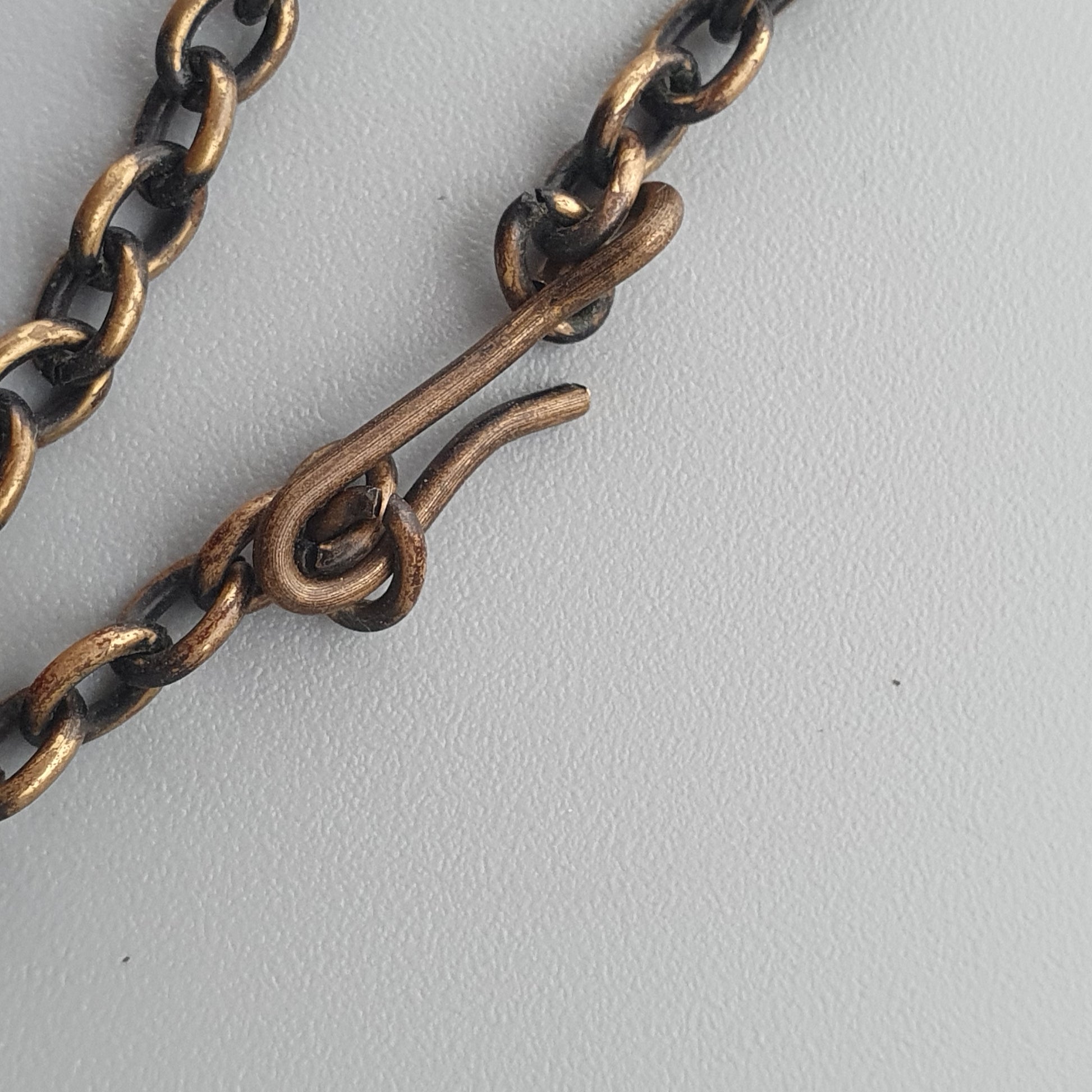 Metal chain with a hook or clasp attachment.