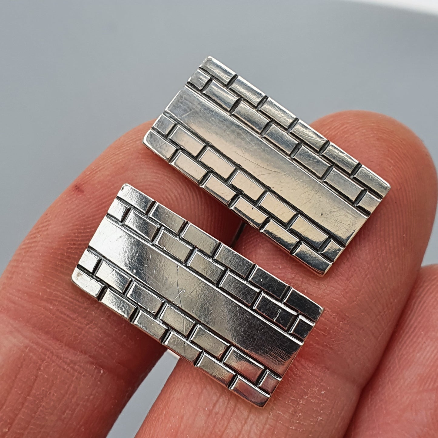 Silver ring with a brick wall pattern design.