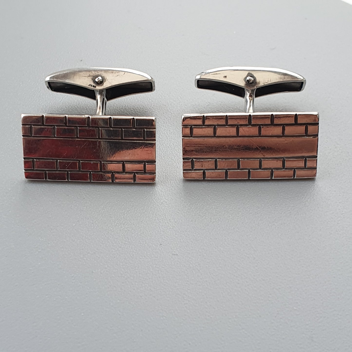 Pair of rectangular cufflinks designed to resemble brick walls.