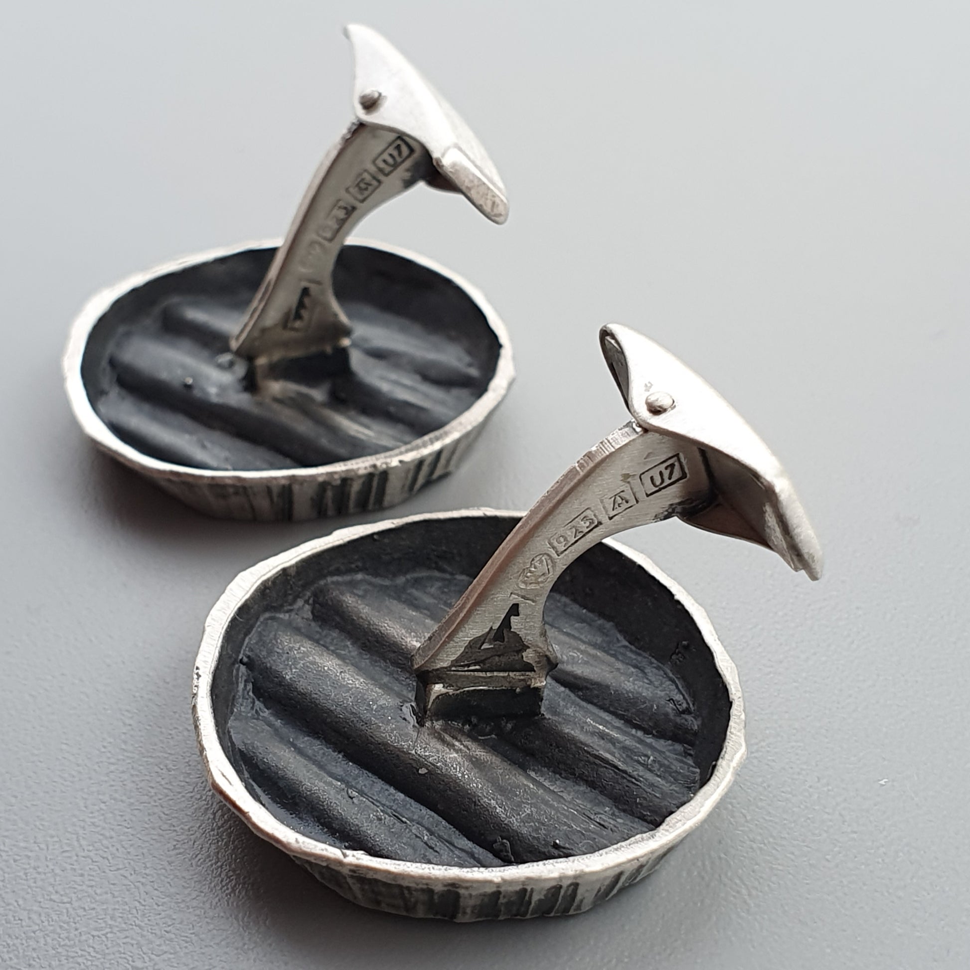 Pair of silver sundial cufflinks with black inlaid faces.