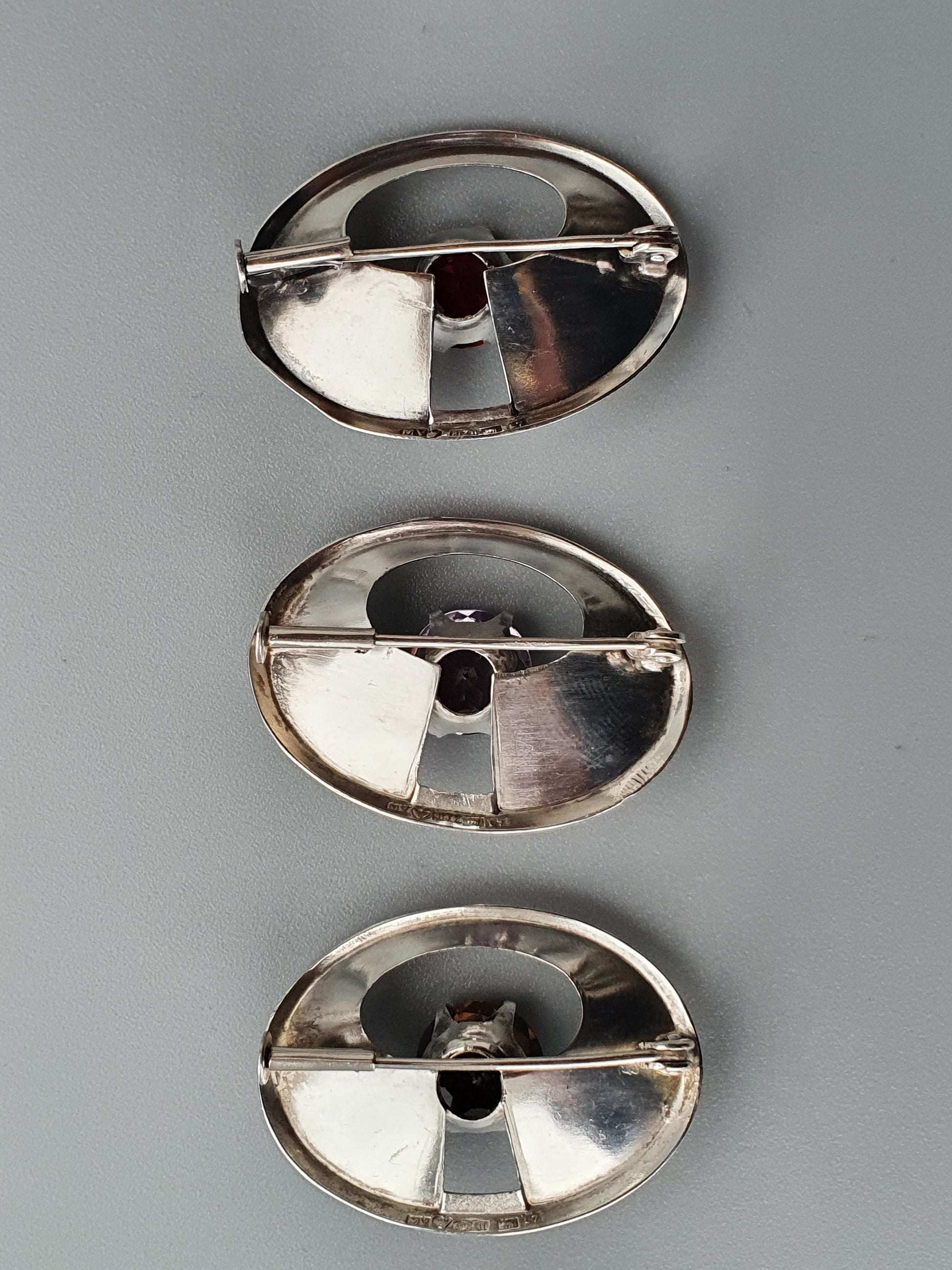 Metallic oval-shaped objects with a central divider and hole.