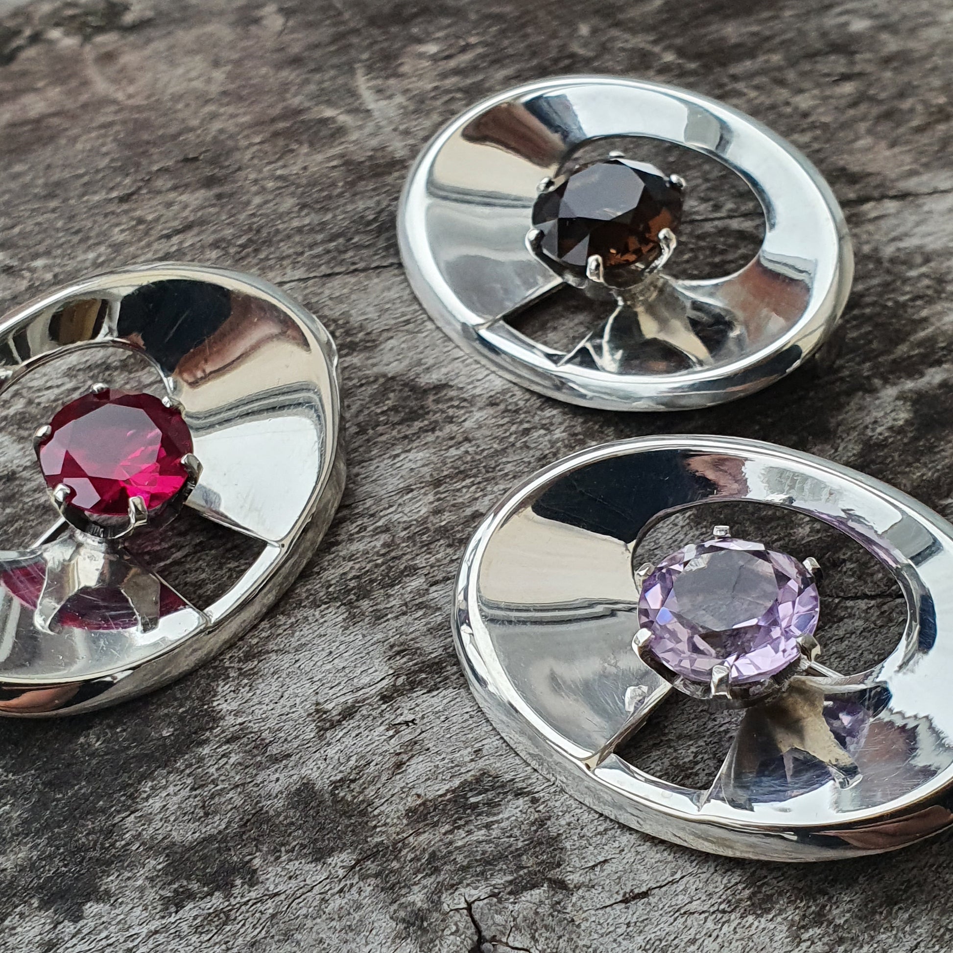 Gemstones set in circular silver or metal settings.