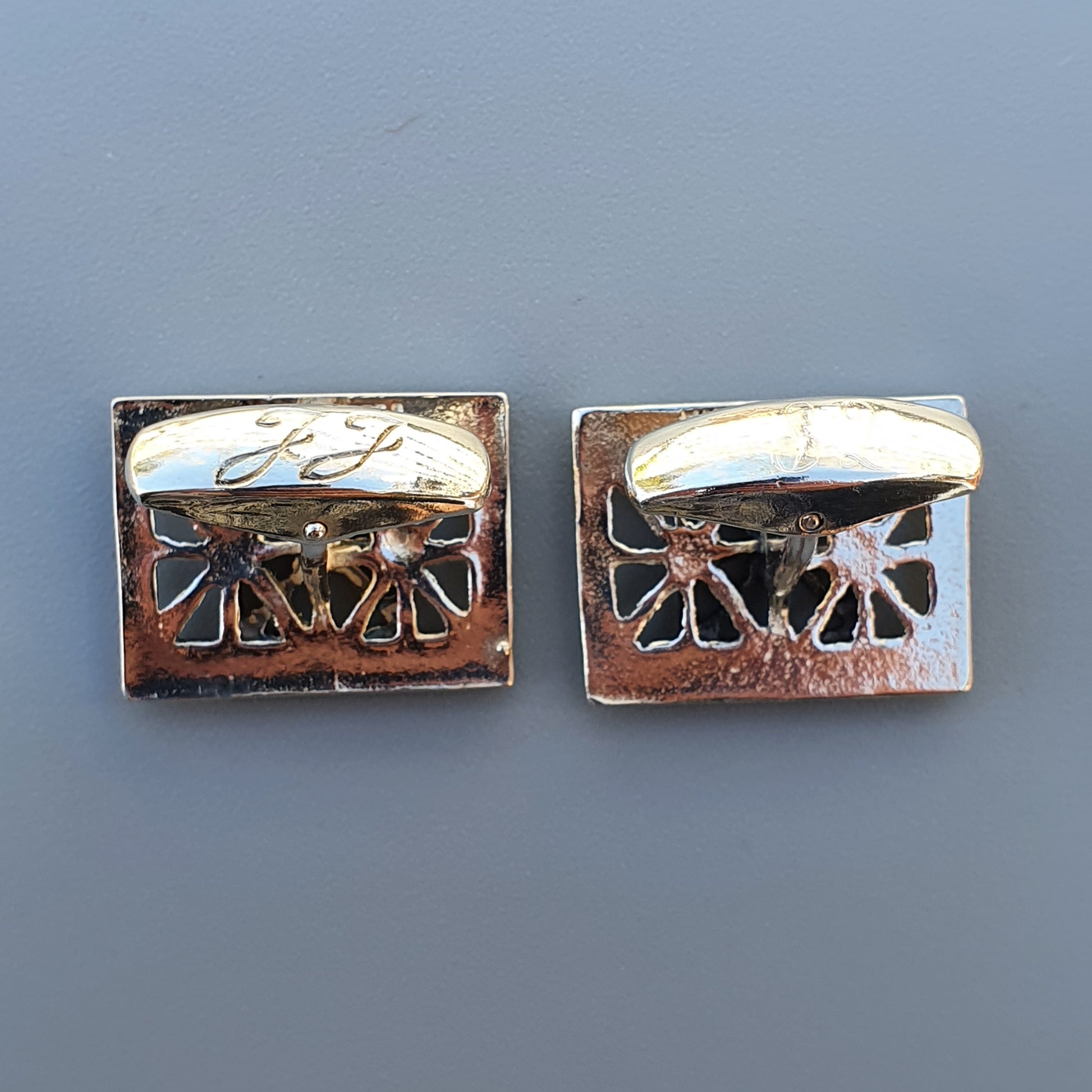 Pair of vintage silver-toned cufflinks with decorative cutout designs.