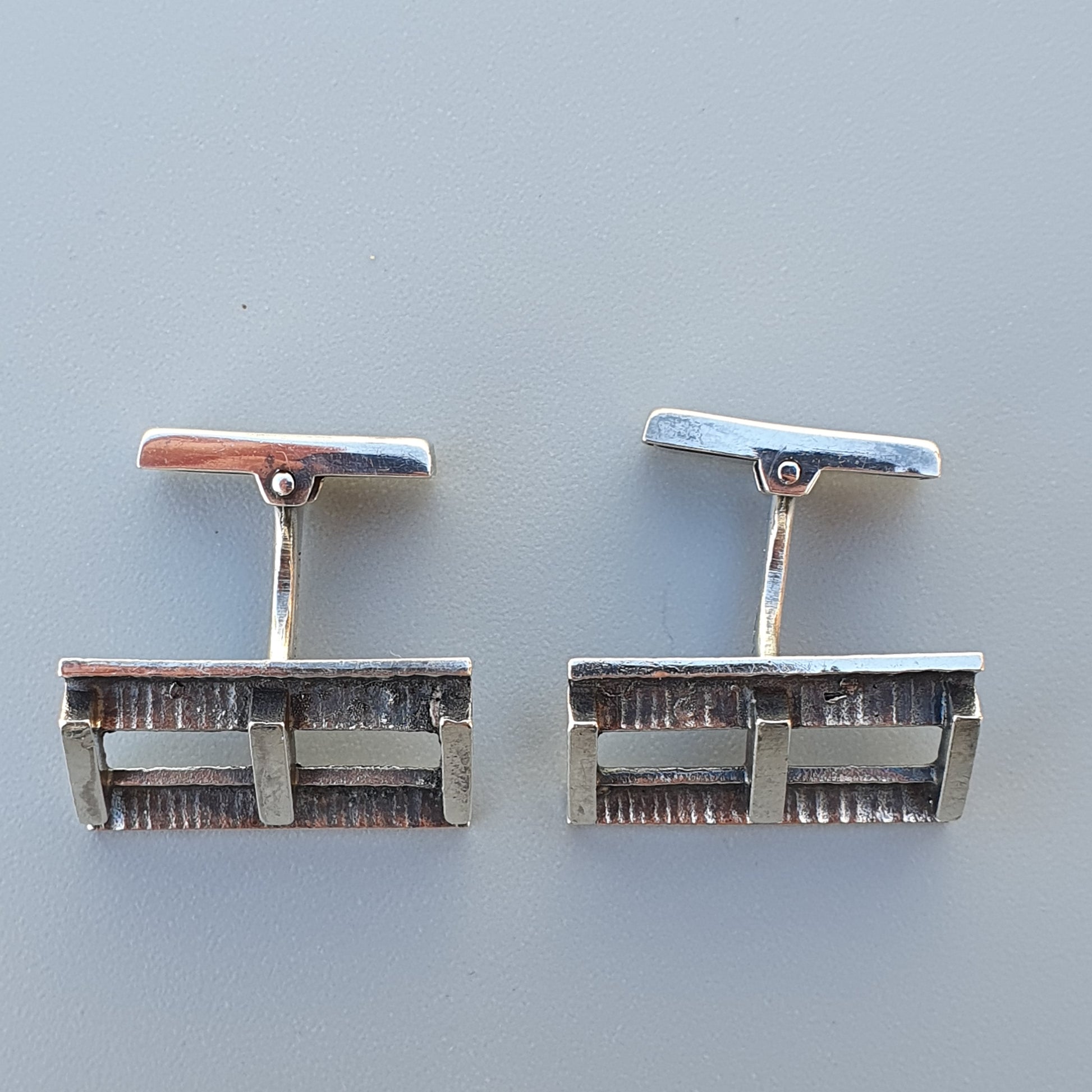 Pair of vintage silver cufflinks with rectangular designs.