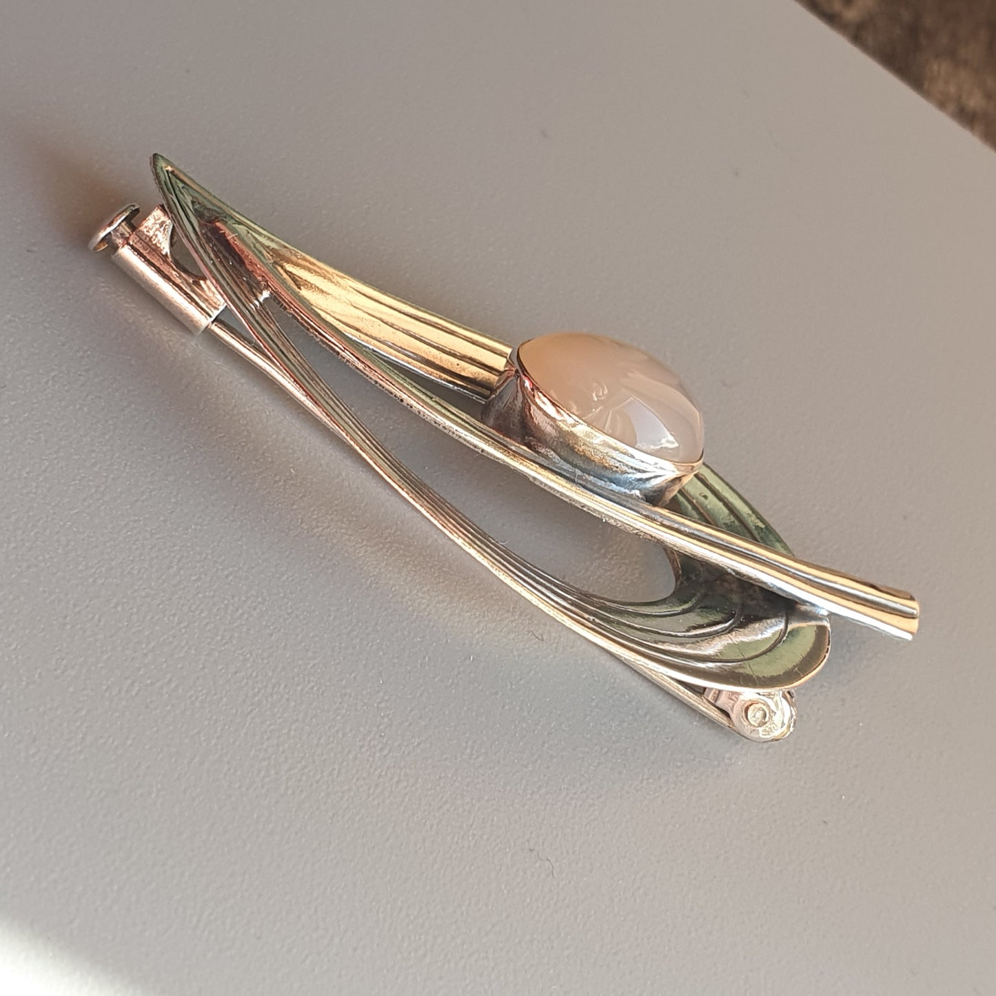 Elegant silver-toned hair clip with a peach-colored gemstone or bead accent.