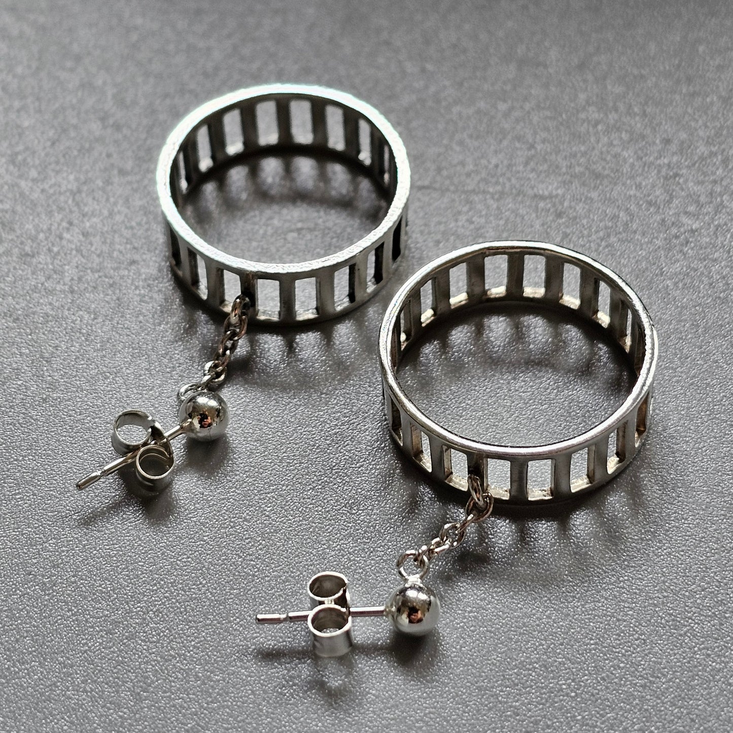 Pair of silver hoop earrings with vertical bar designs.