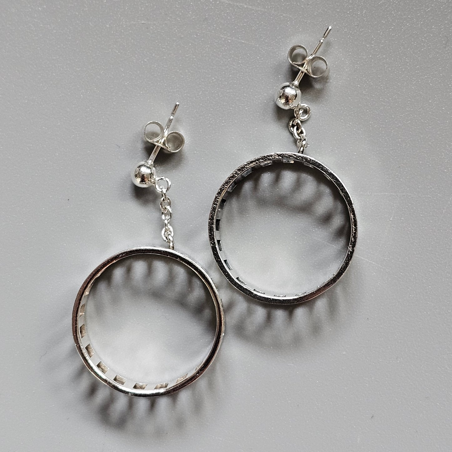 Pair of silver hoop earrings with stud attachments.