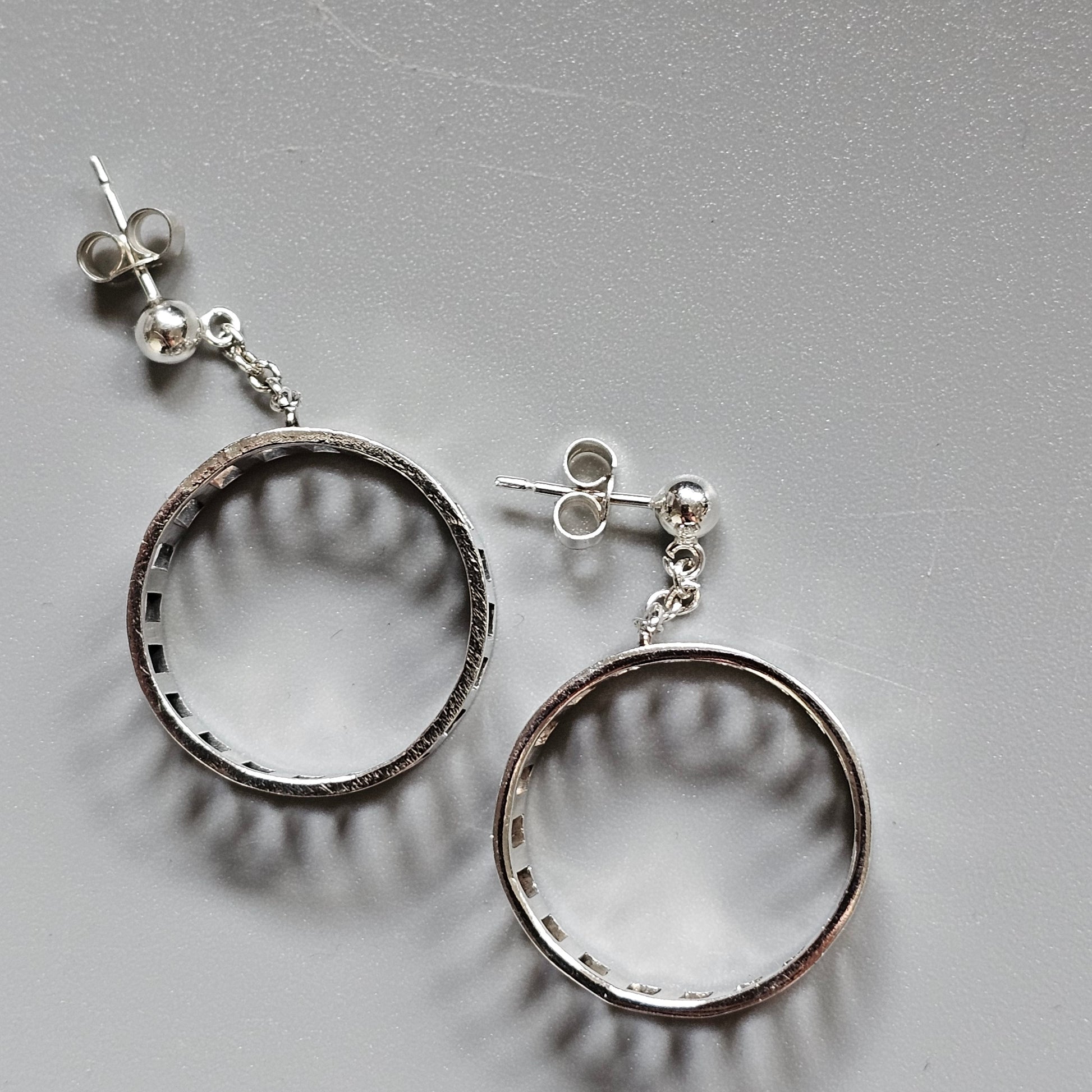 Pair of silver hoop earrings with stud attachments.