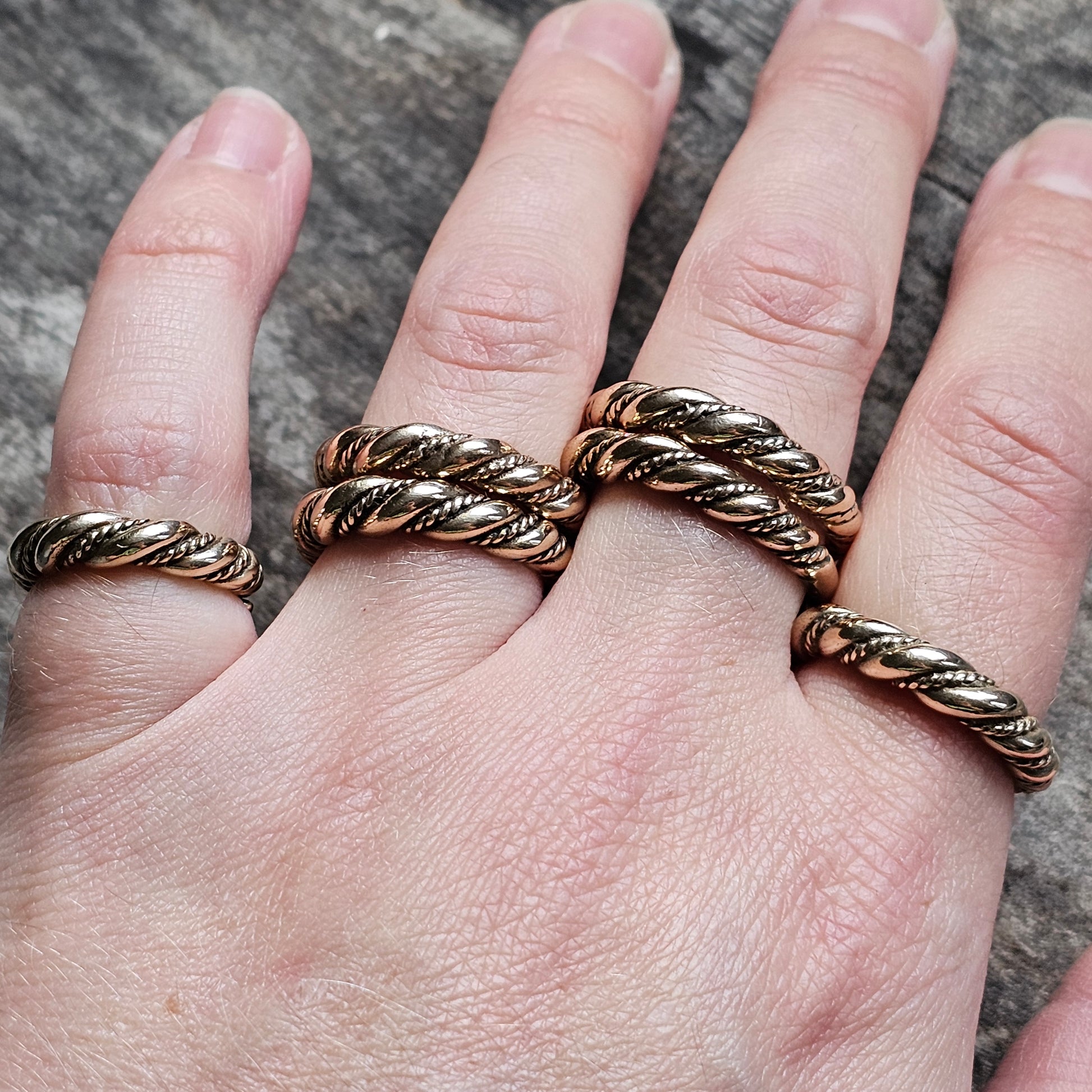 Twisted metal rings worn on multiple fingers.