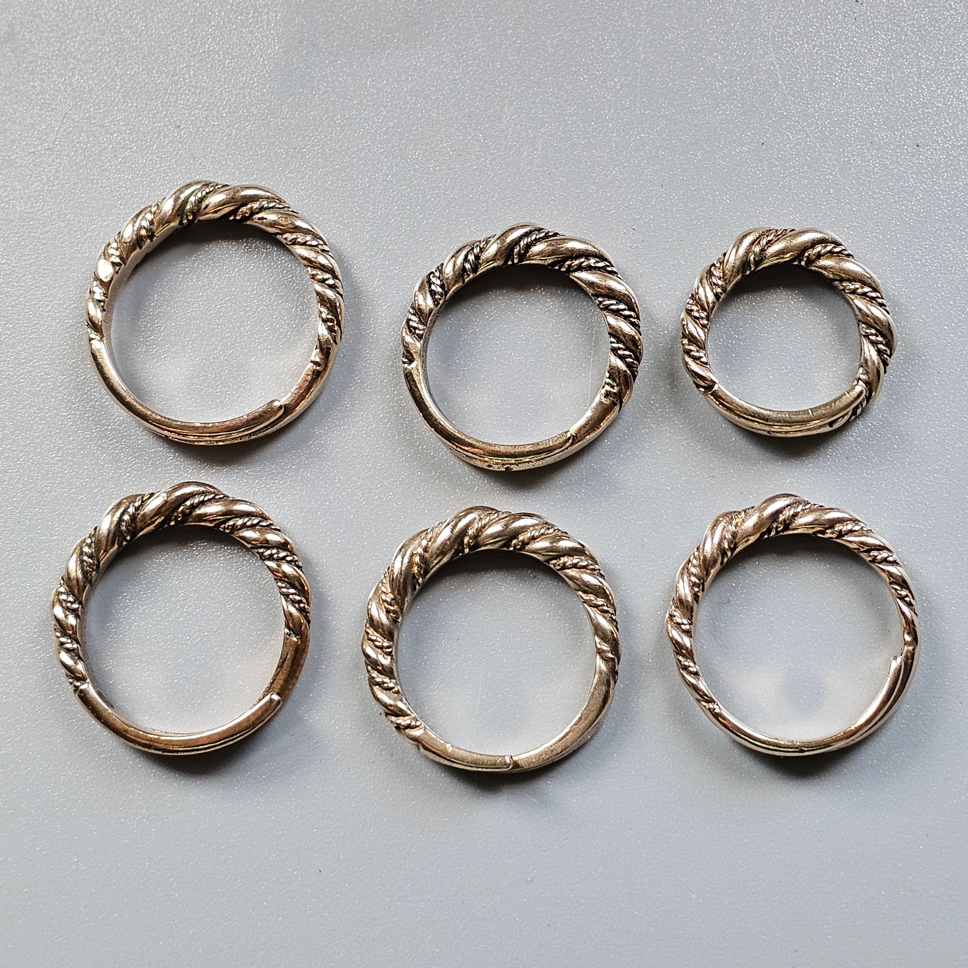 Six twisted metal rings arranged in two rows.