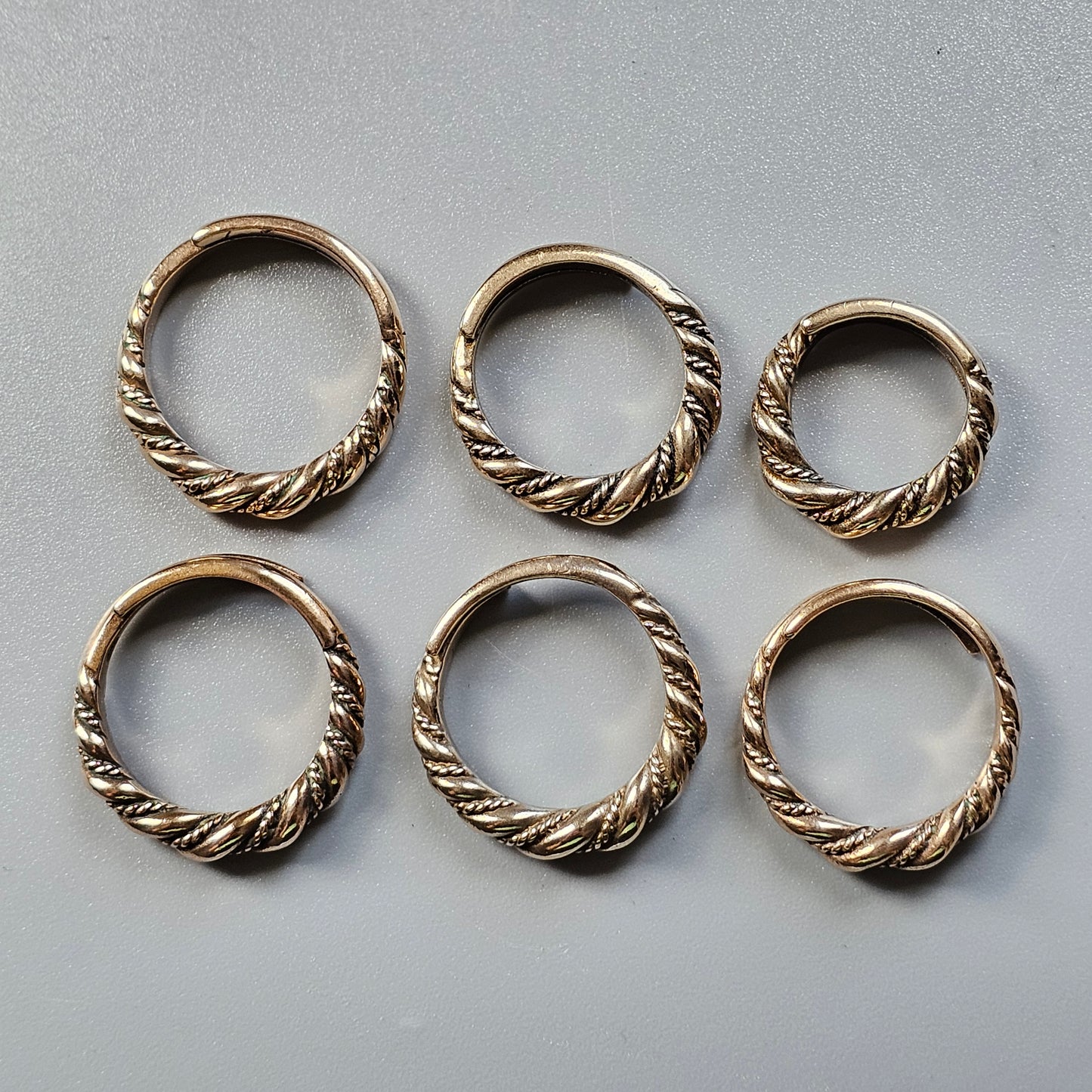 Six twisted metal rings arranged in two rows.