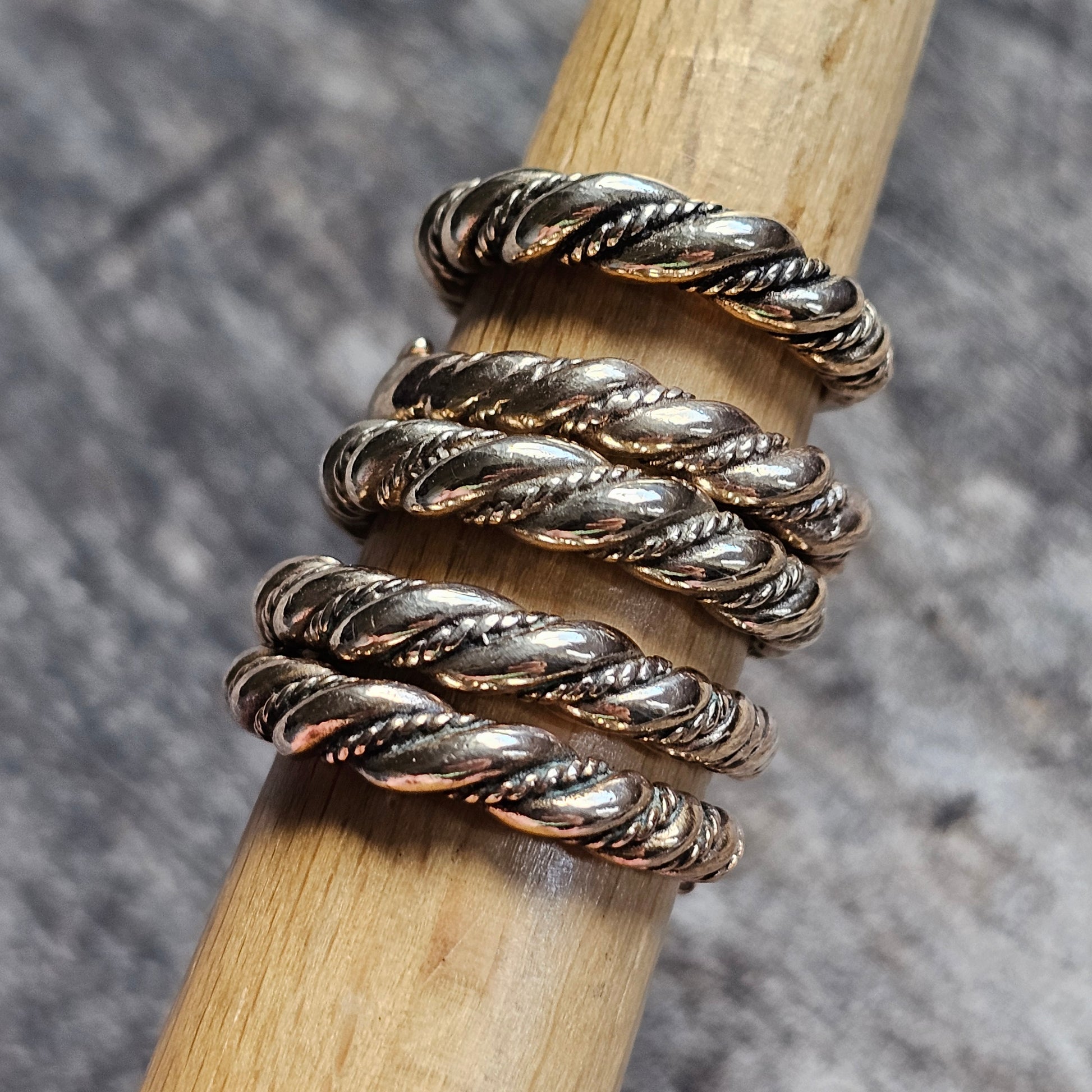 Twisted silver metal ring with multiple coils resembling a spiral.