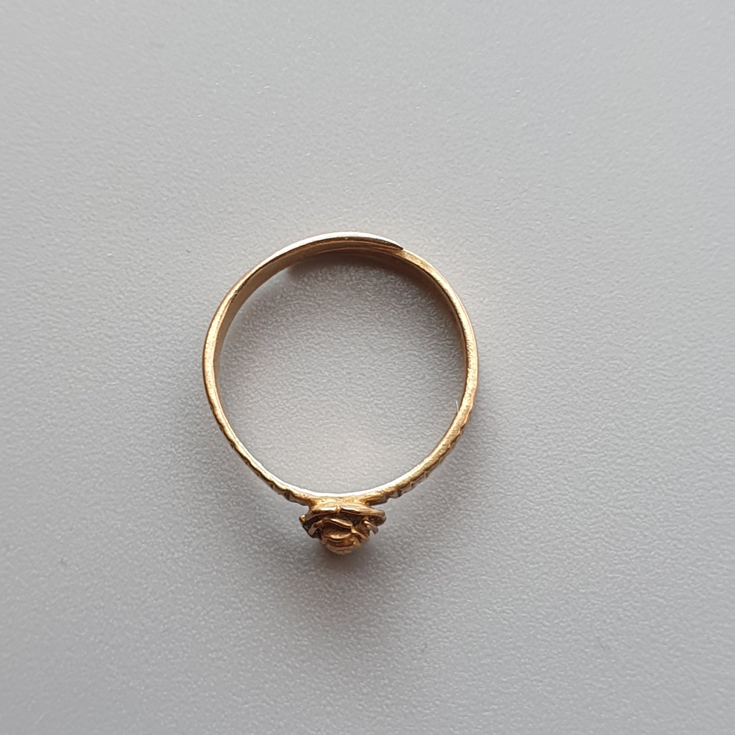 Gold ring with a small amber-colored gemstone.