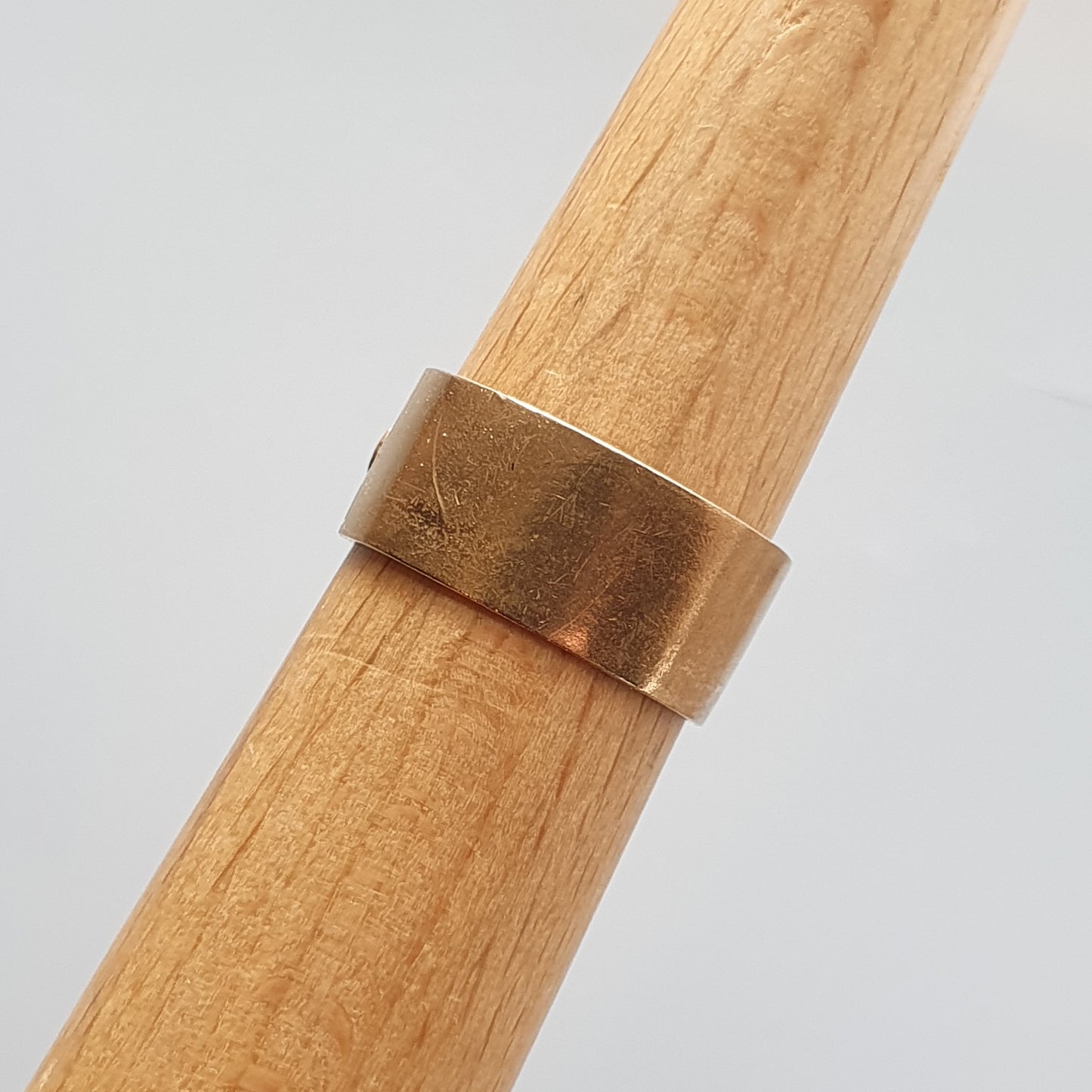 Gold-colored metal ring on a wooden surface.