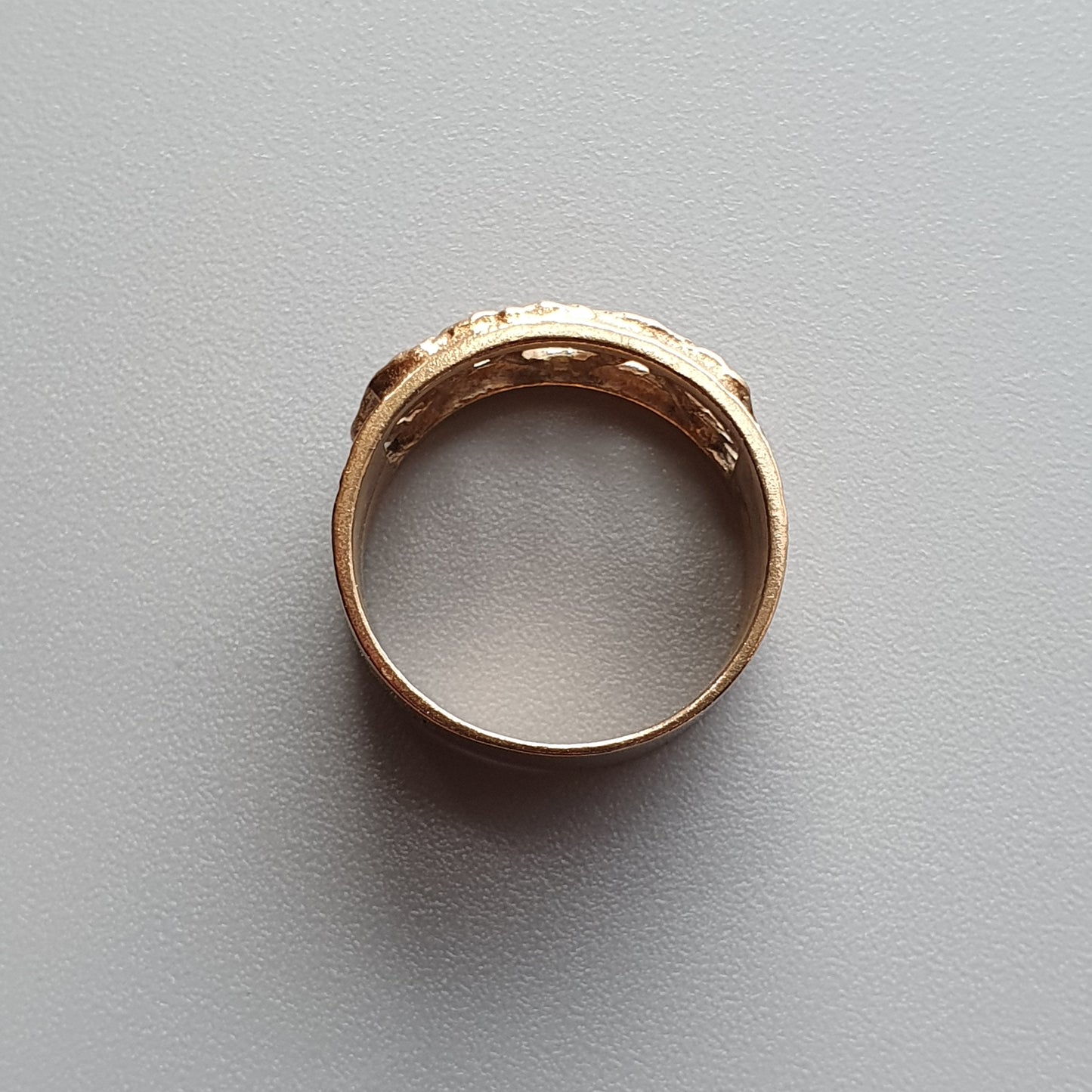 Gold ring with small embedded gemstones or diamonds.