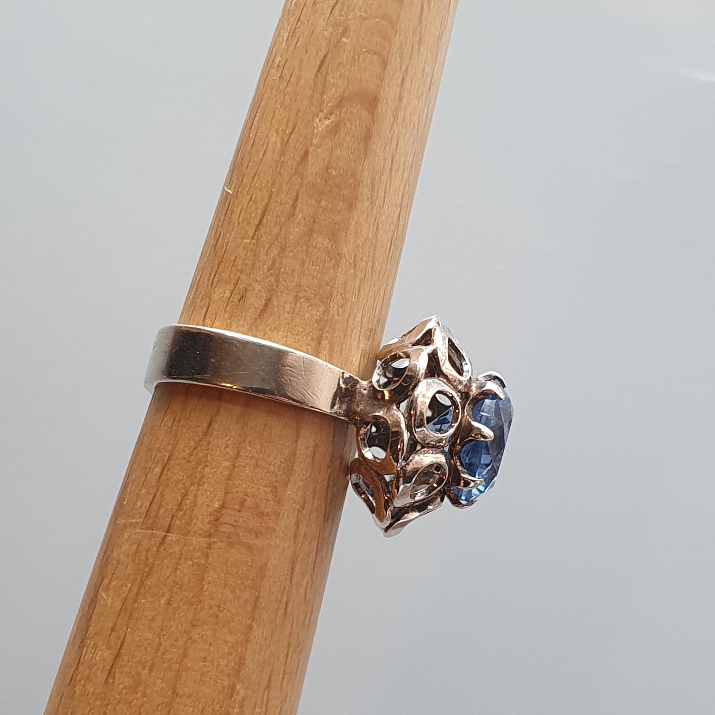 Ring with an ornate silver setting featuring a blue gemstone.