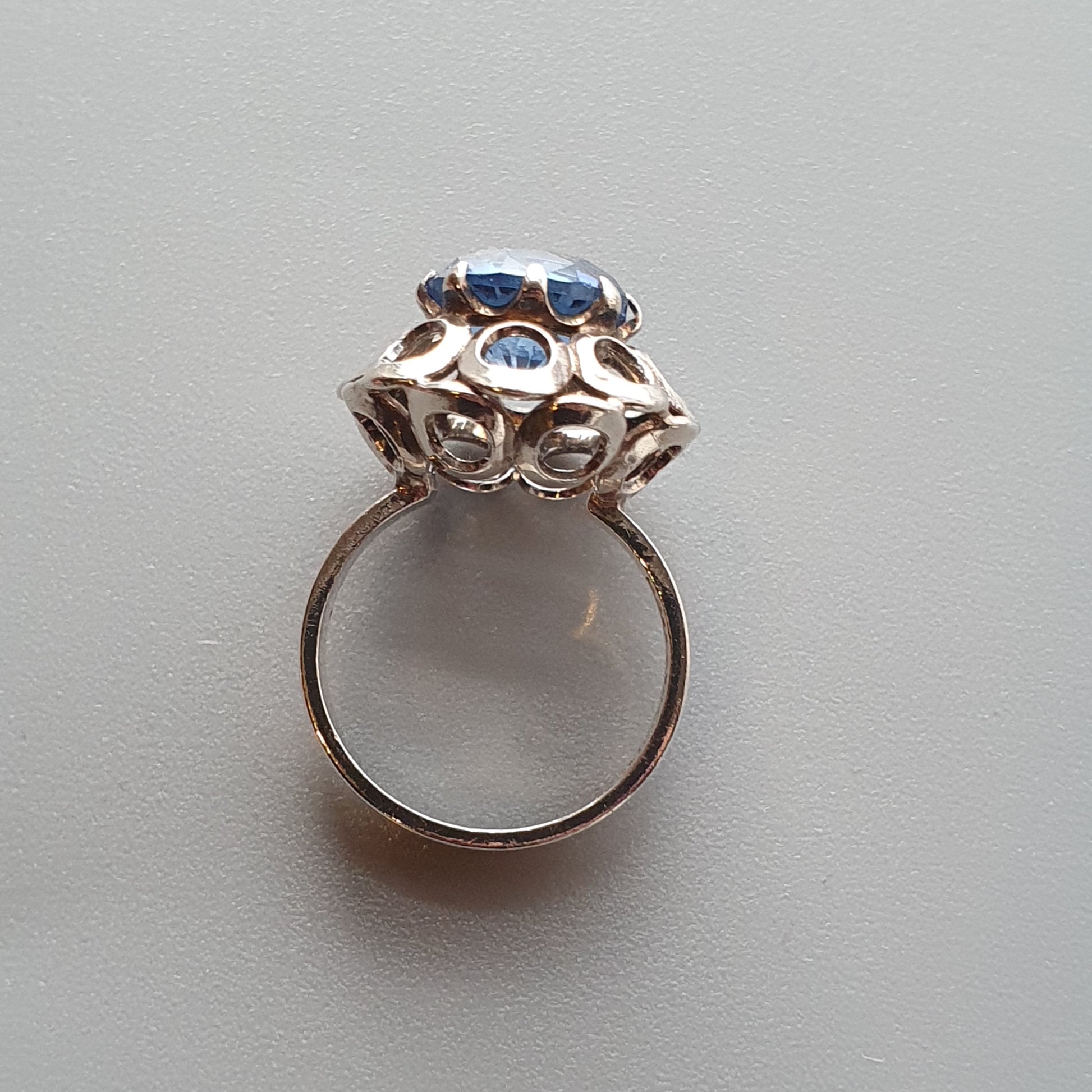 Ornate silver ring with a prominent blue gemstone in an intricate setting.