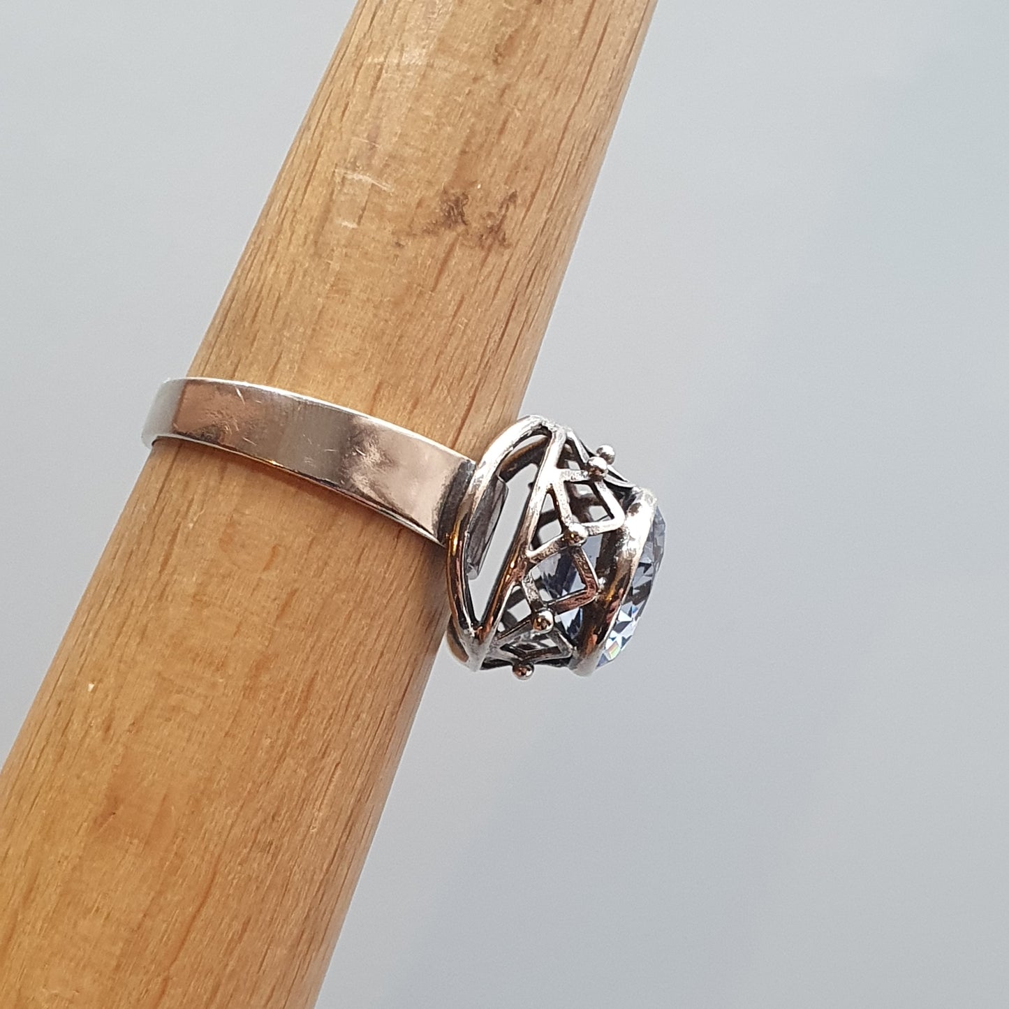 Silver ring with an intricate spherical cage-like design on top.