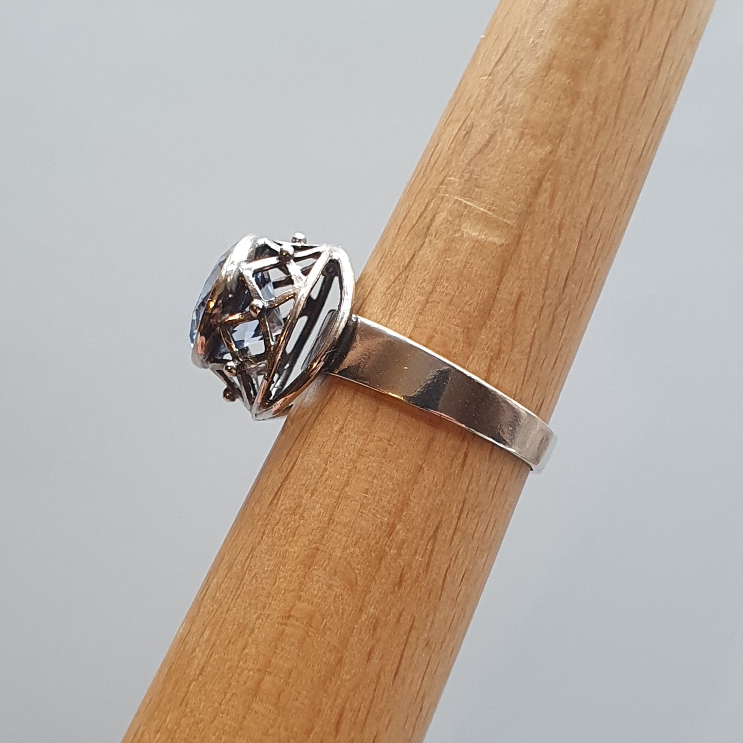 Silver ring with an intricate geometric design on top.