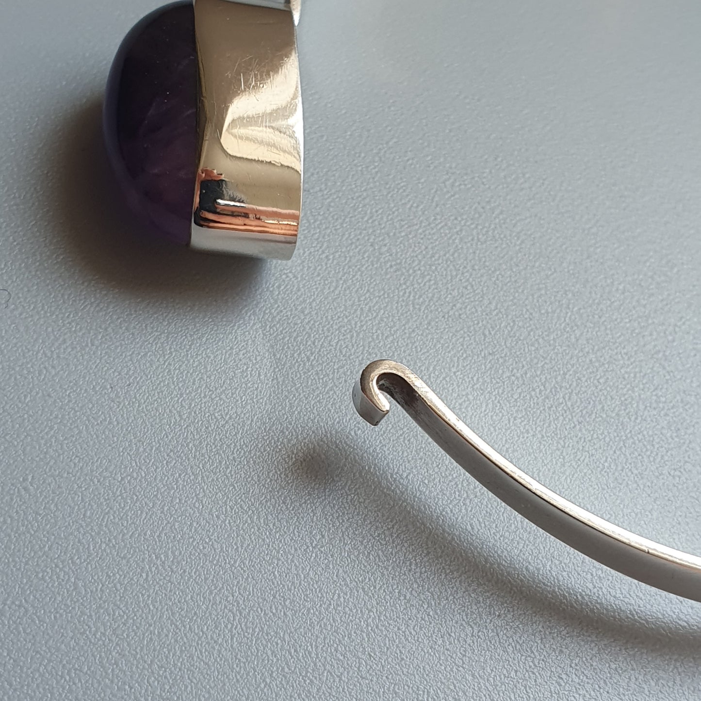 Curved metal wire or hook with a simple, minimalist design.