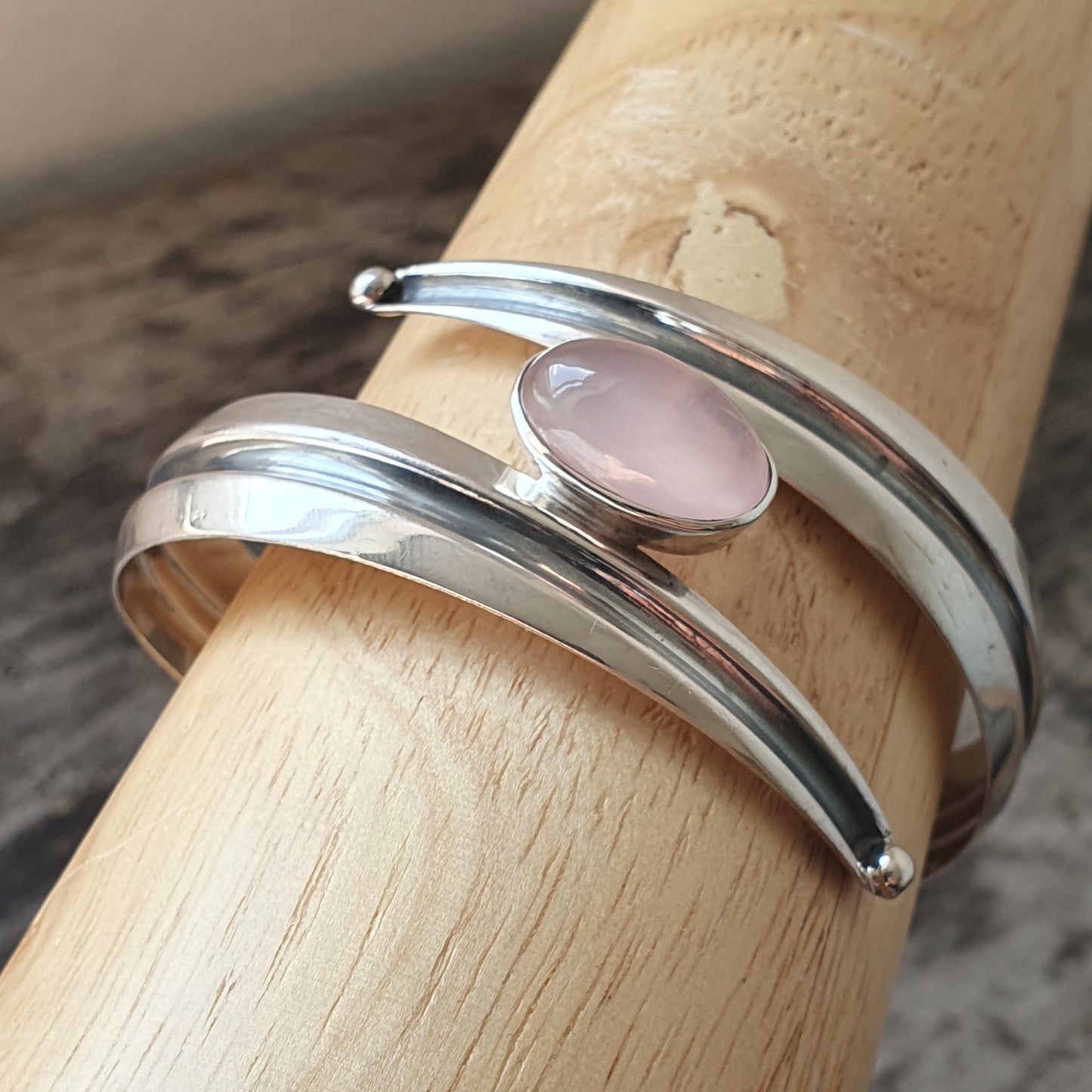 Silver bracelet with a pale pink gemstone or cabochon.