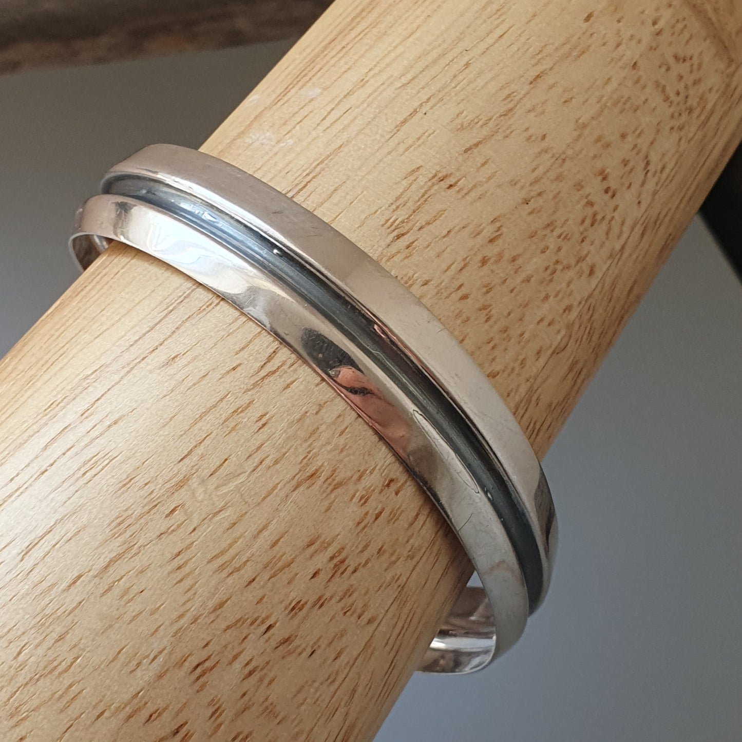 Silver metal bracelet or bangle with a simple, sleek design.