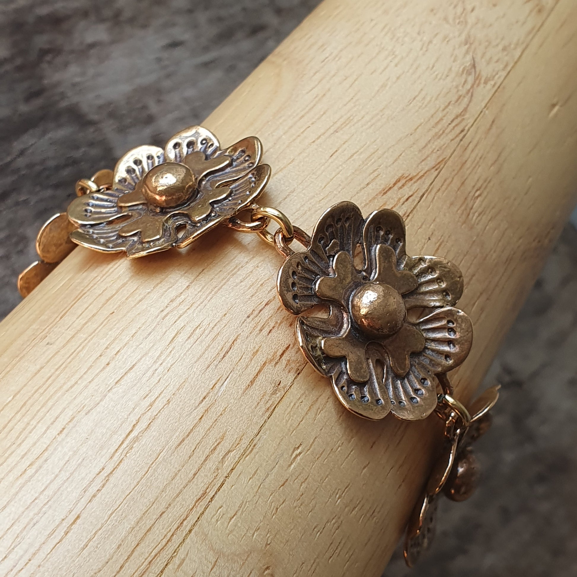 Delicate floral bracelet with metallic flower-shaped links.