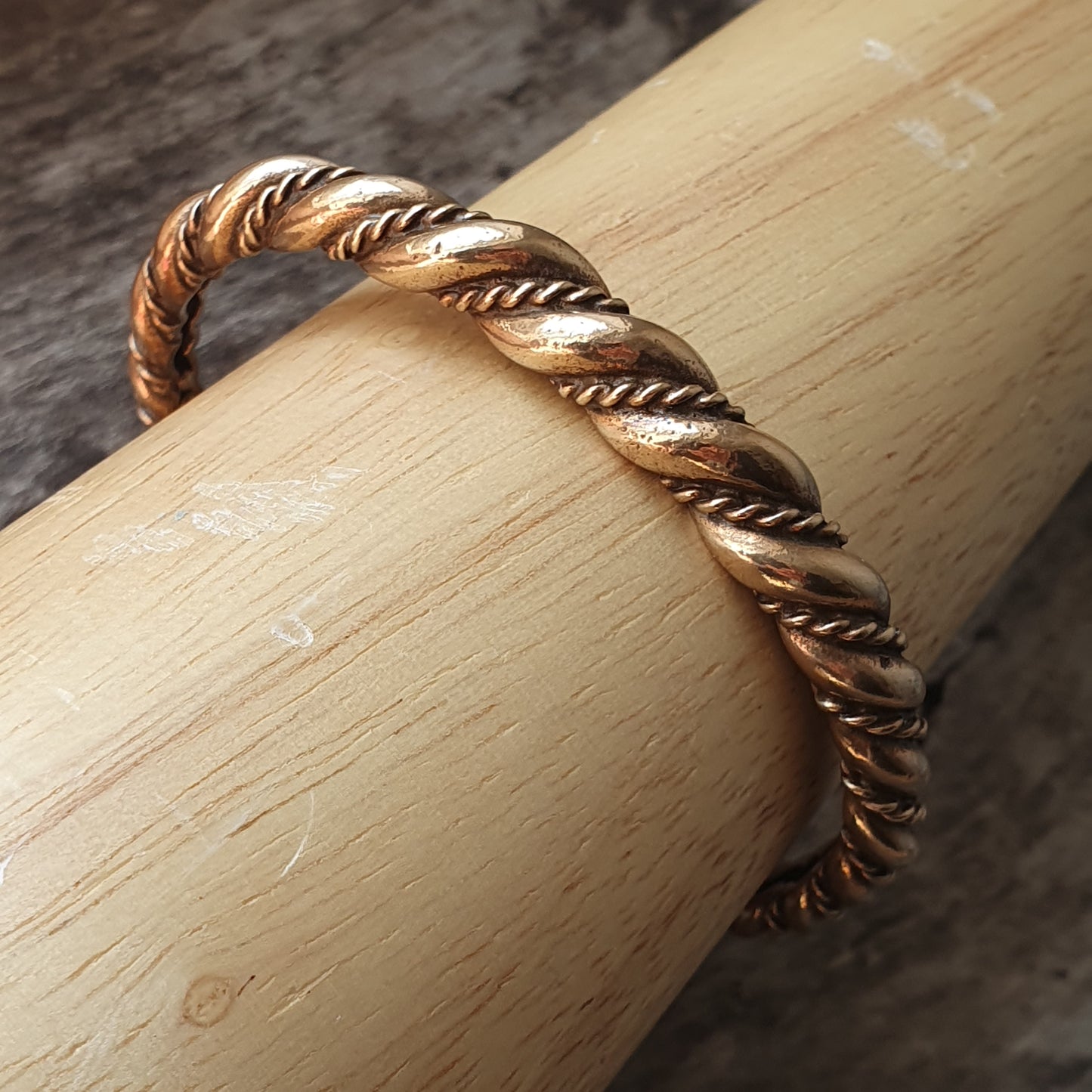 Twisted gold and silver metallic ring with a rope-like pattern.