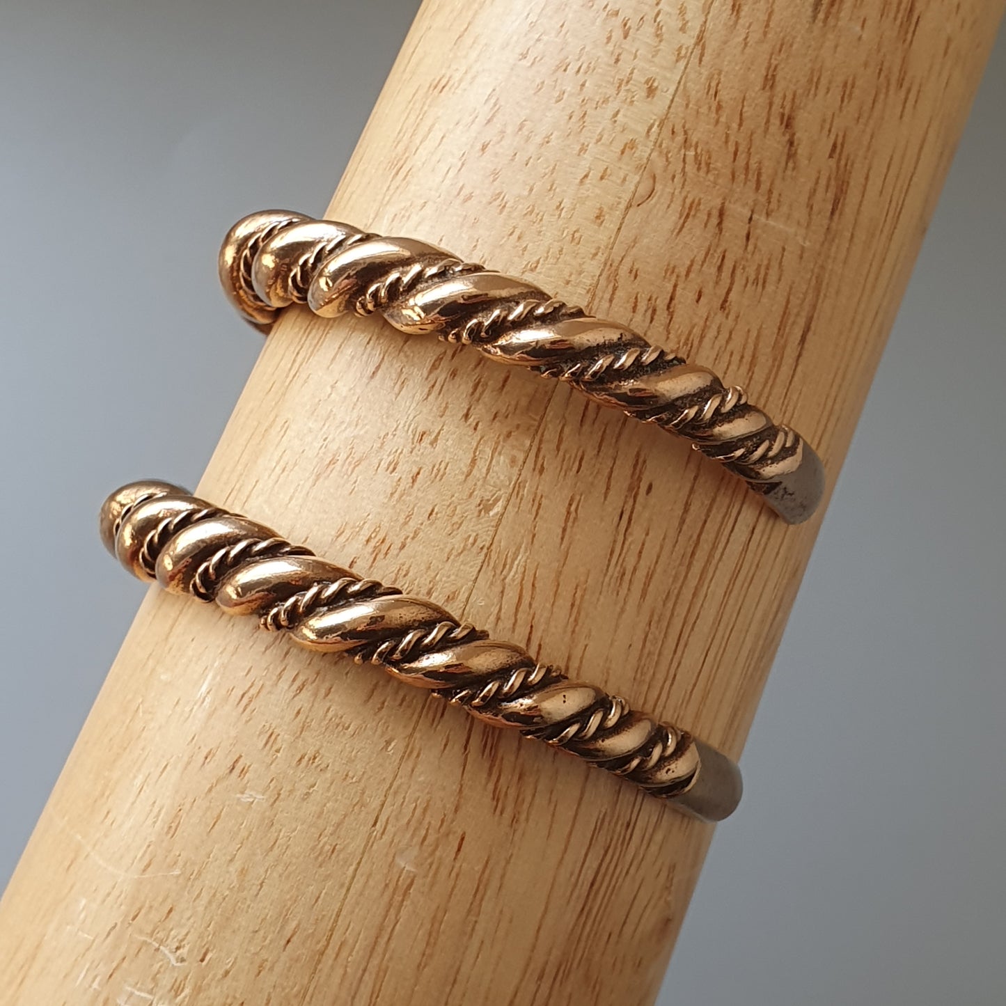 Twisted gold metal rings with a rope-like pattern.