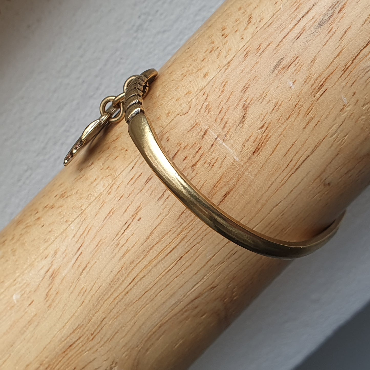 Gold-toned metal bracelet with a hook clasp.