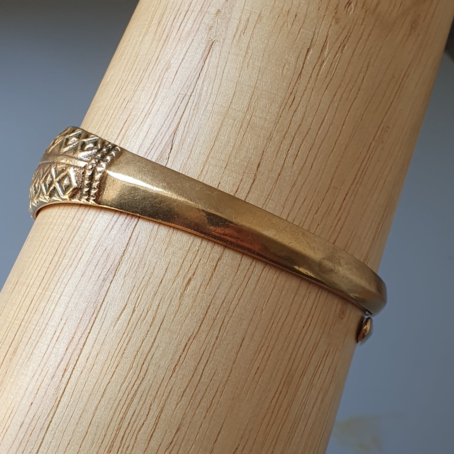 Gold ring with an intricate pattern on part of its band.