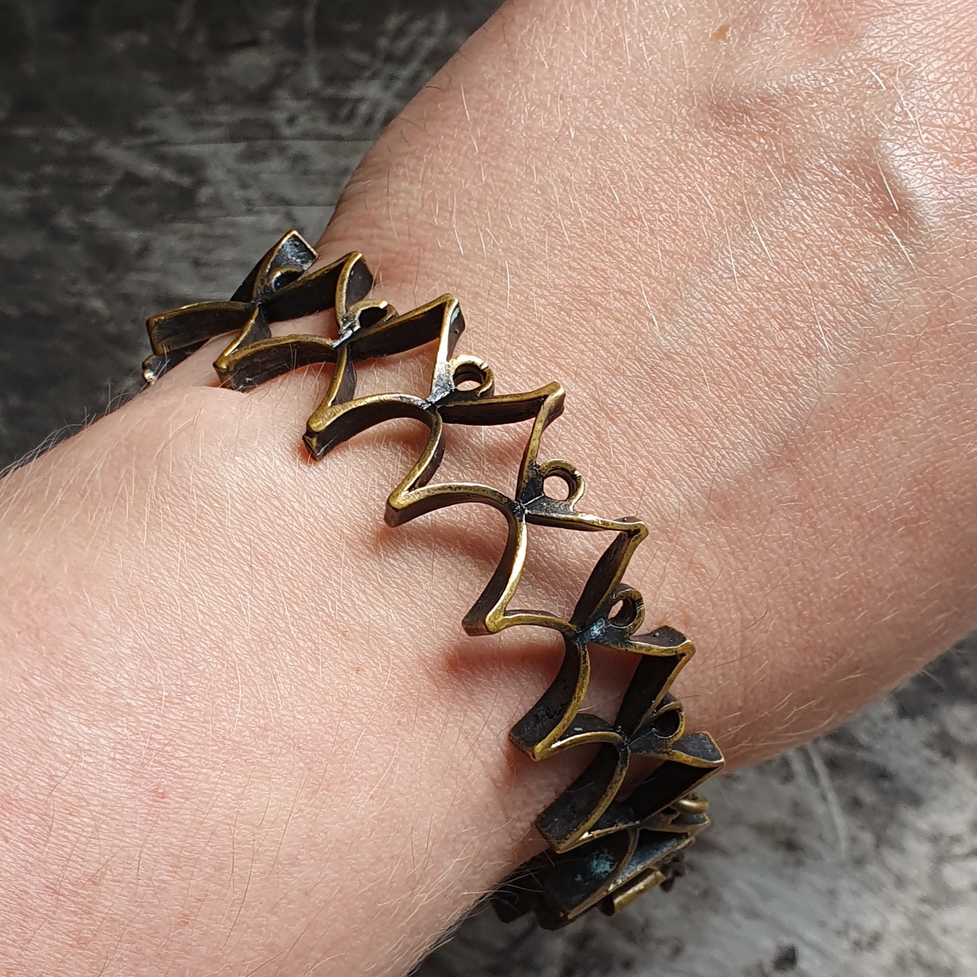 Bronze-colored zigzag bracelet worn on a wrist.