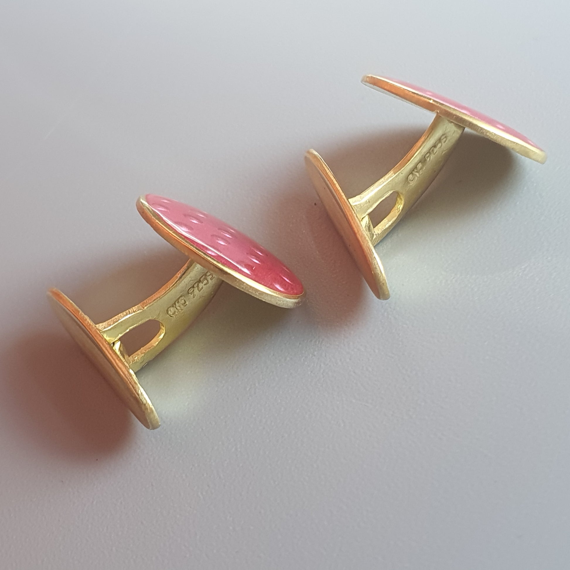 Pair of pink and gold cufflinks shaped like mushrooms or toadstools.