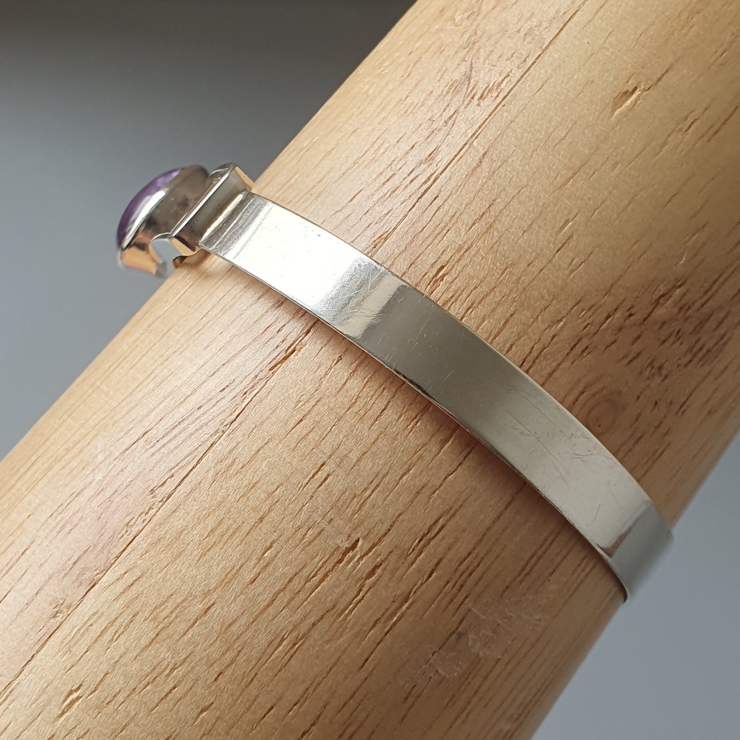 Silver metal bracelet or bangle with a simple, flat design.