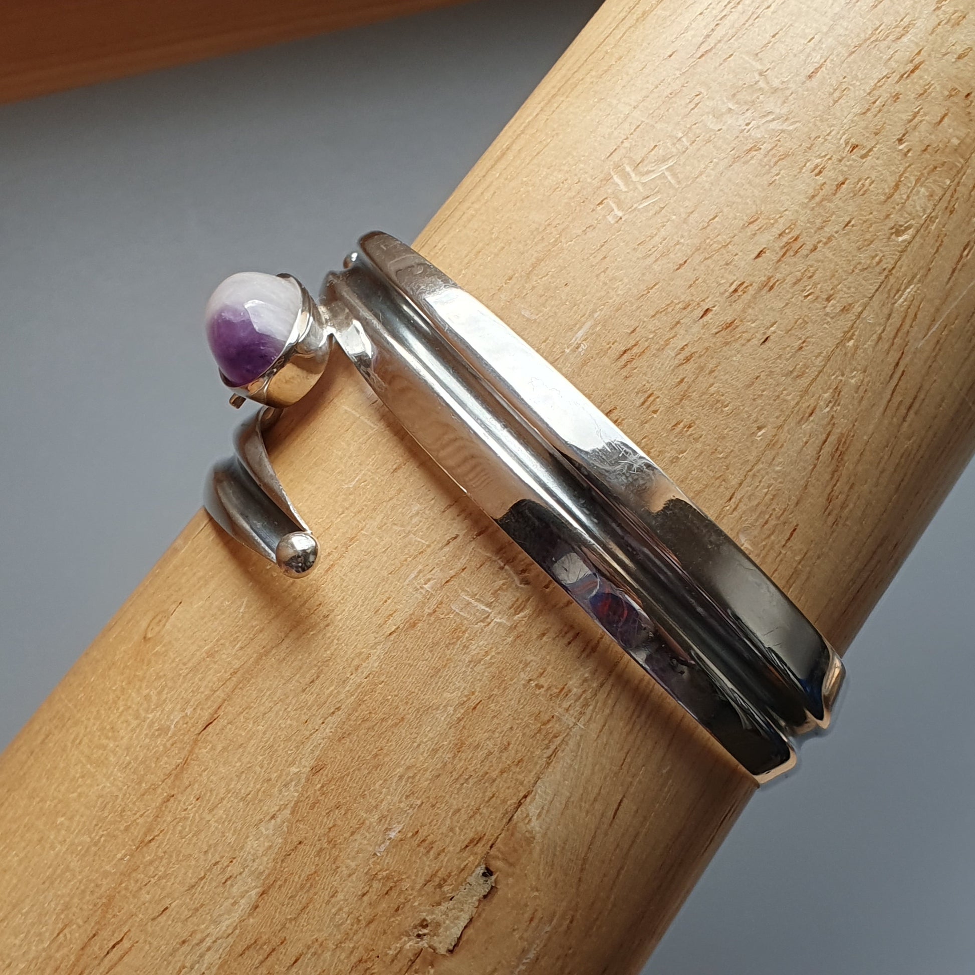 Silver ring with a small purple gemstone or bead accent.